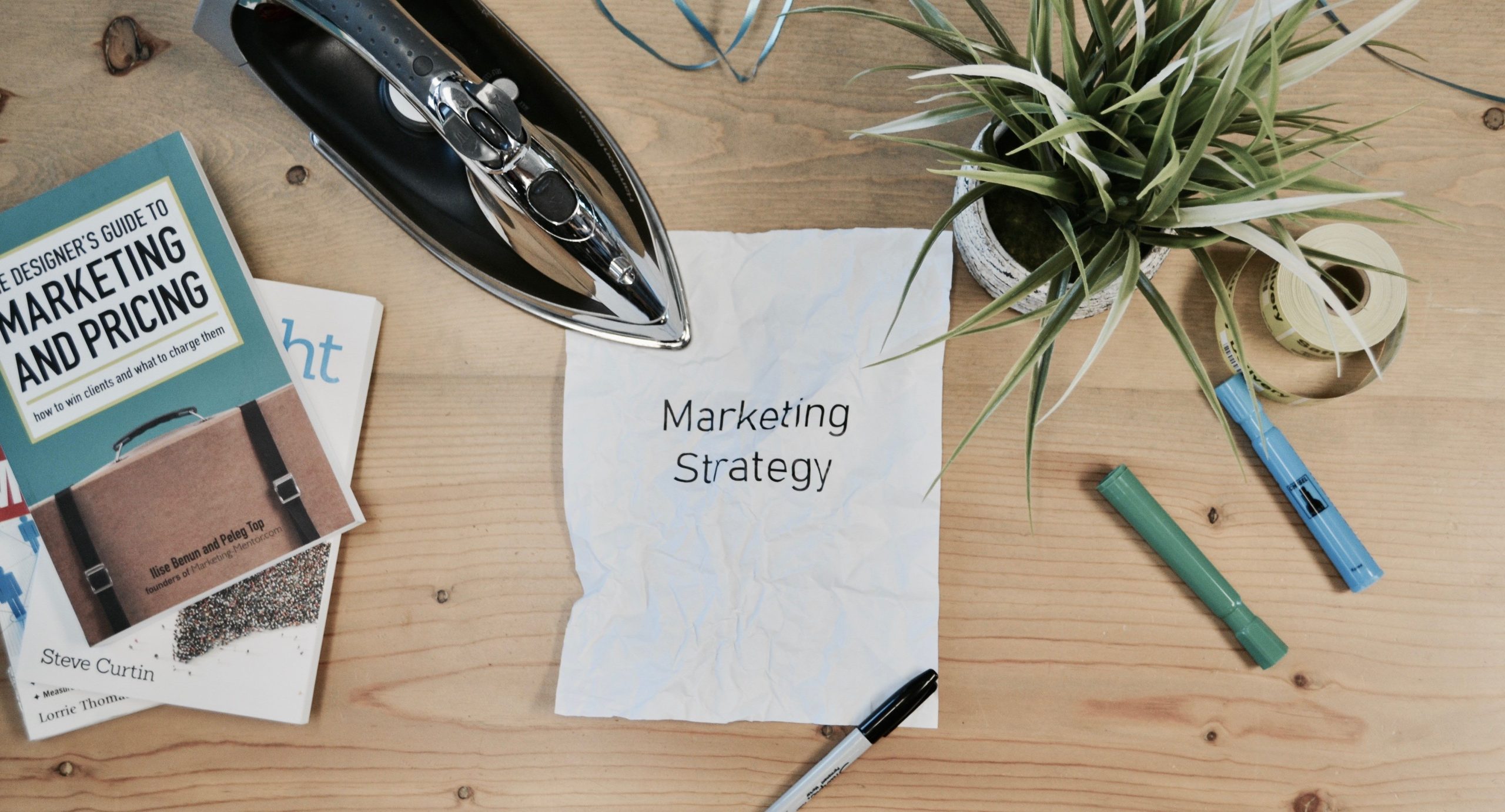 The words 'Marketing Strategy' written on a crumpled piece of paper on a desk.