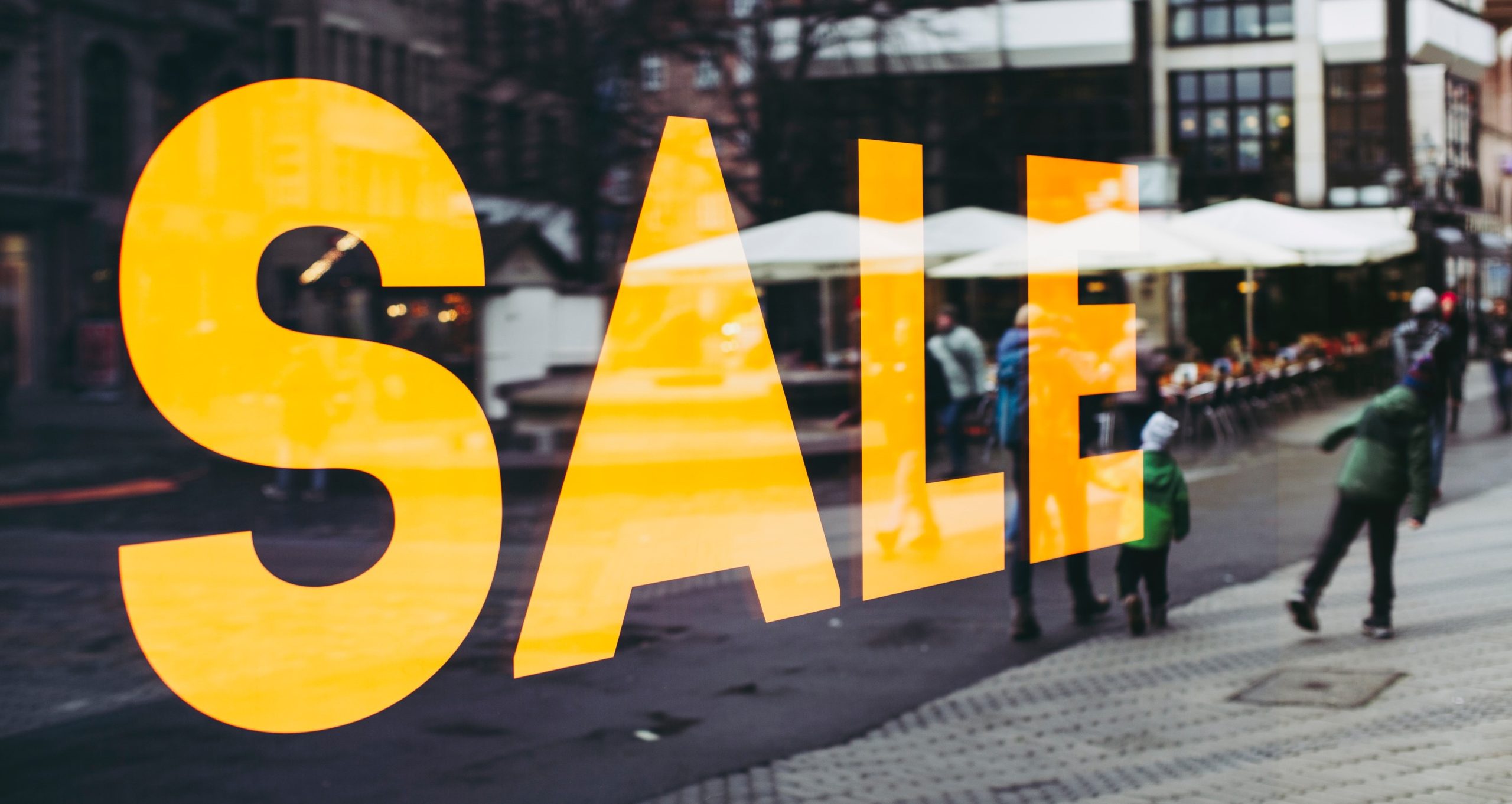 The word 'sale' written in bold, yellow letters on a shop window.