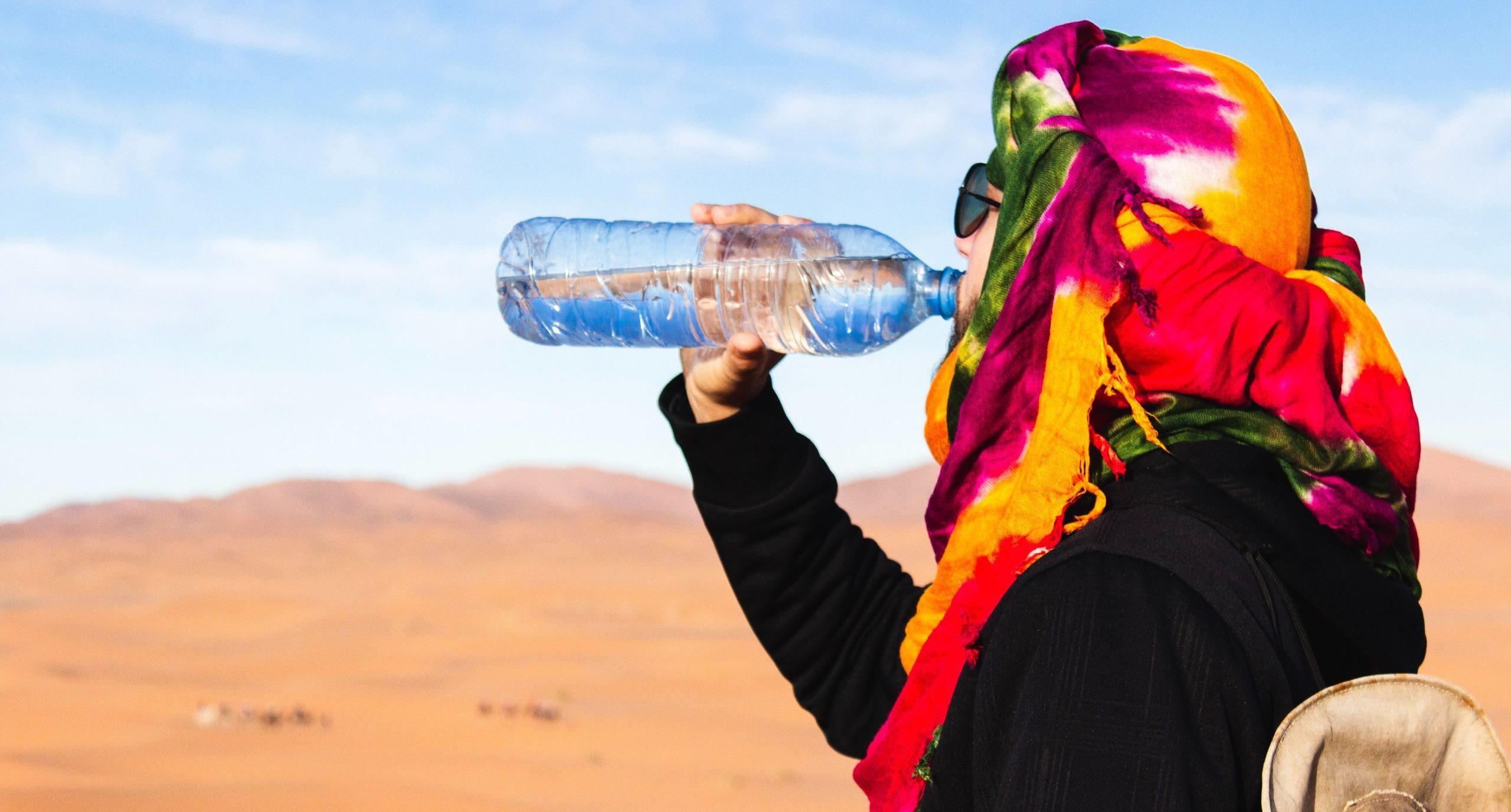 Man drinking water in the desert.