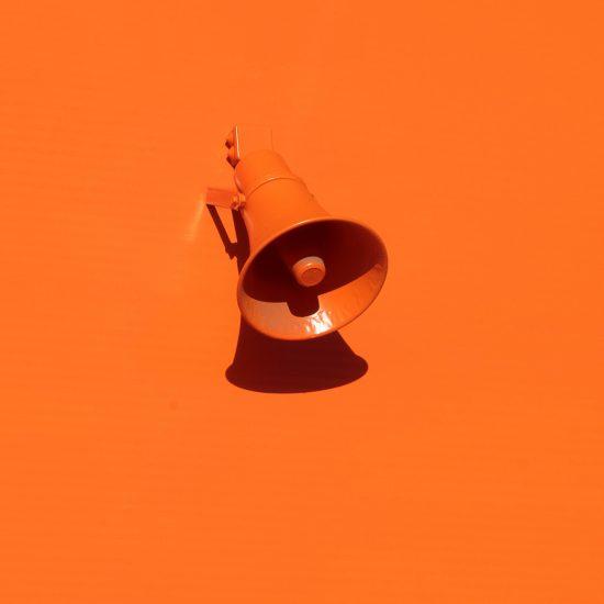 Orange megaphone against an orange background as part of an article about company values.