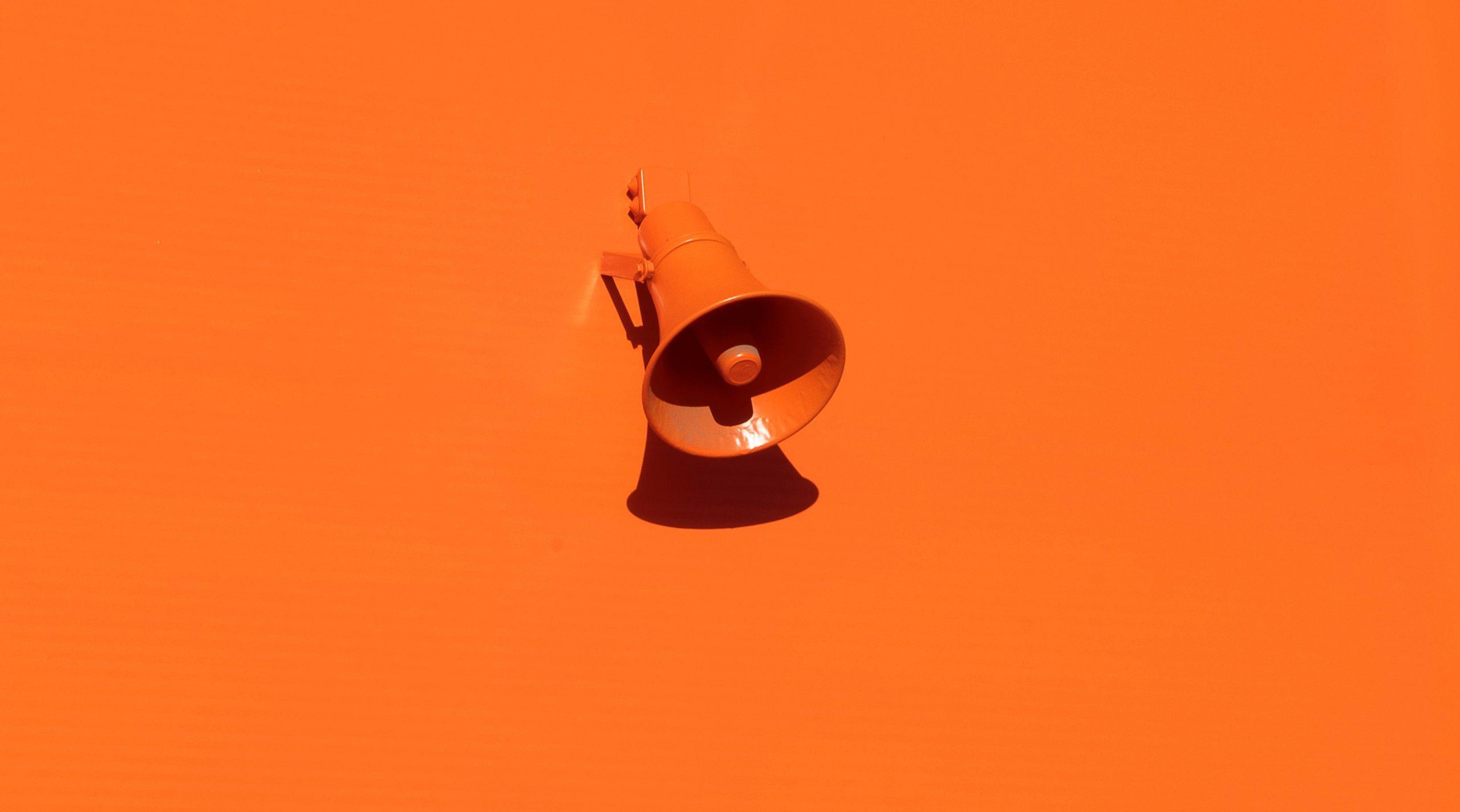 Orange megaphone against an orange background as part of an article about company values.
