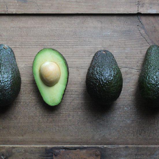 One half, upturned avocado among a trio of unopened avocados as part of an article about niche marketing.