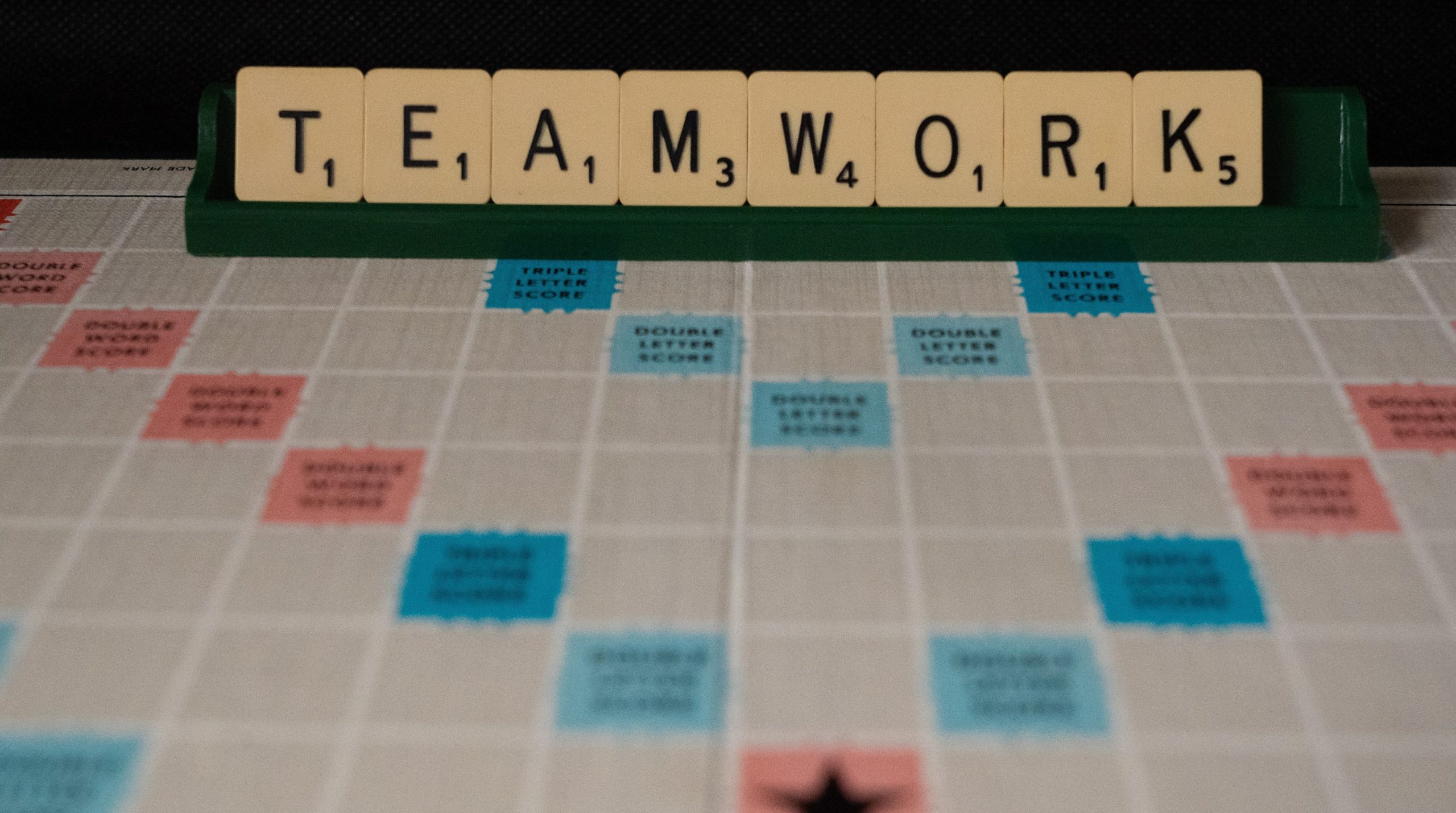 The word 'teamwork' spelled out with Scrabble letters.