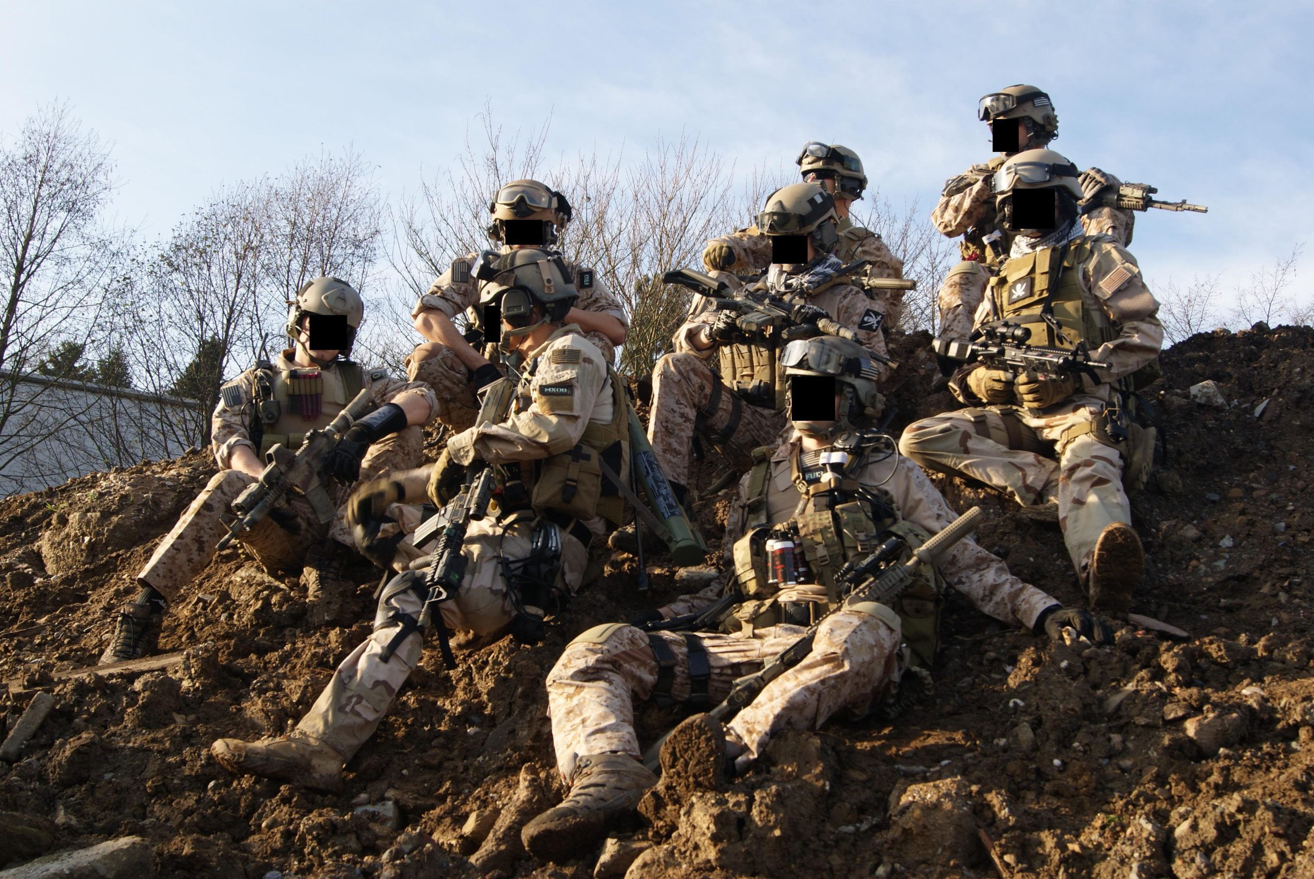 US Navy SEALs posing atop a hill.