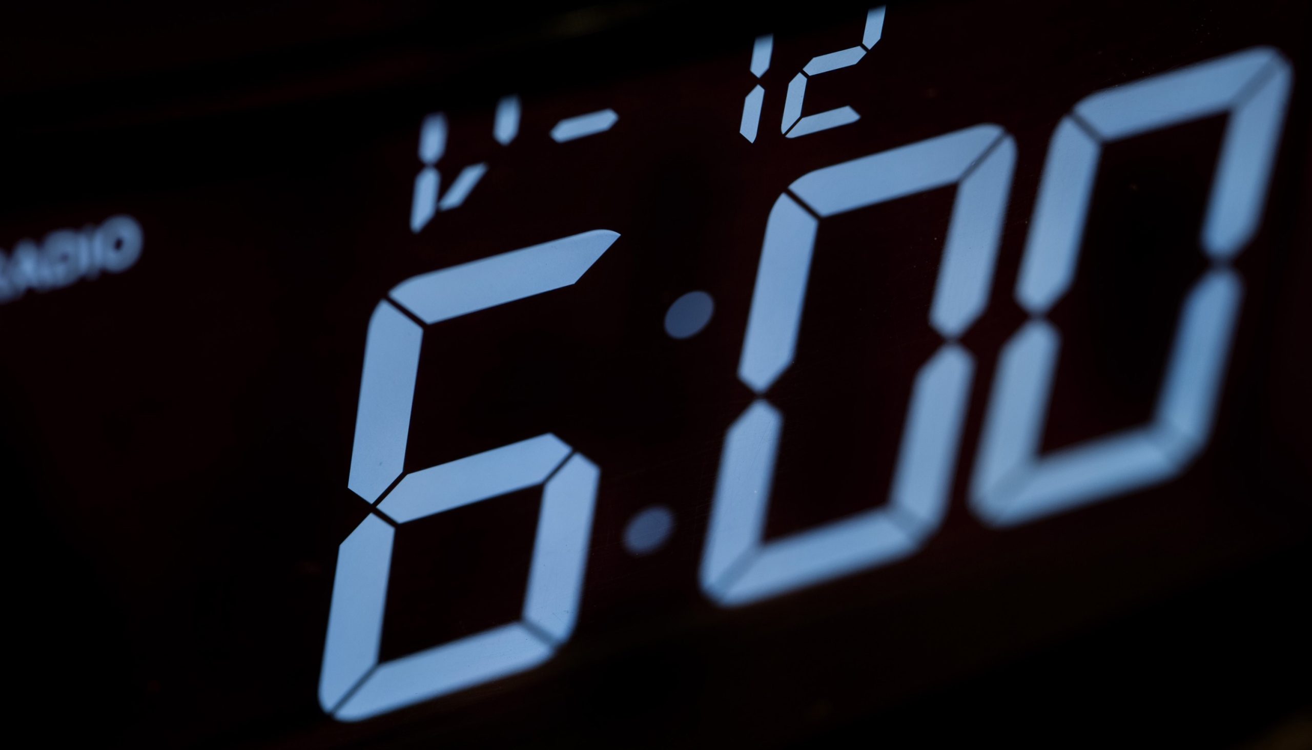 Digital alarm clock displaying time of 6 o'clock.