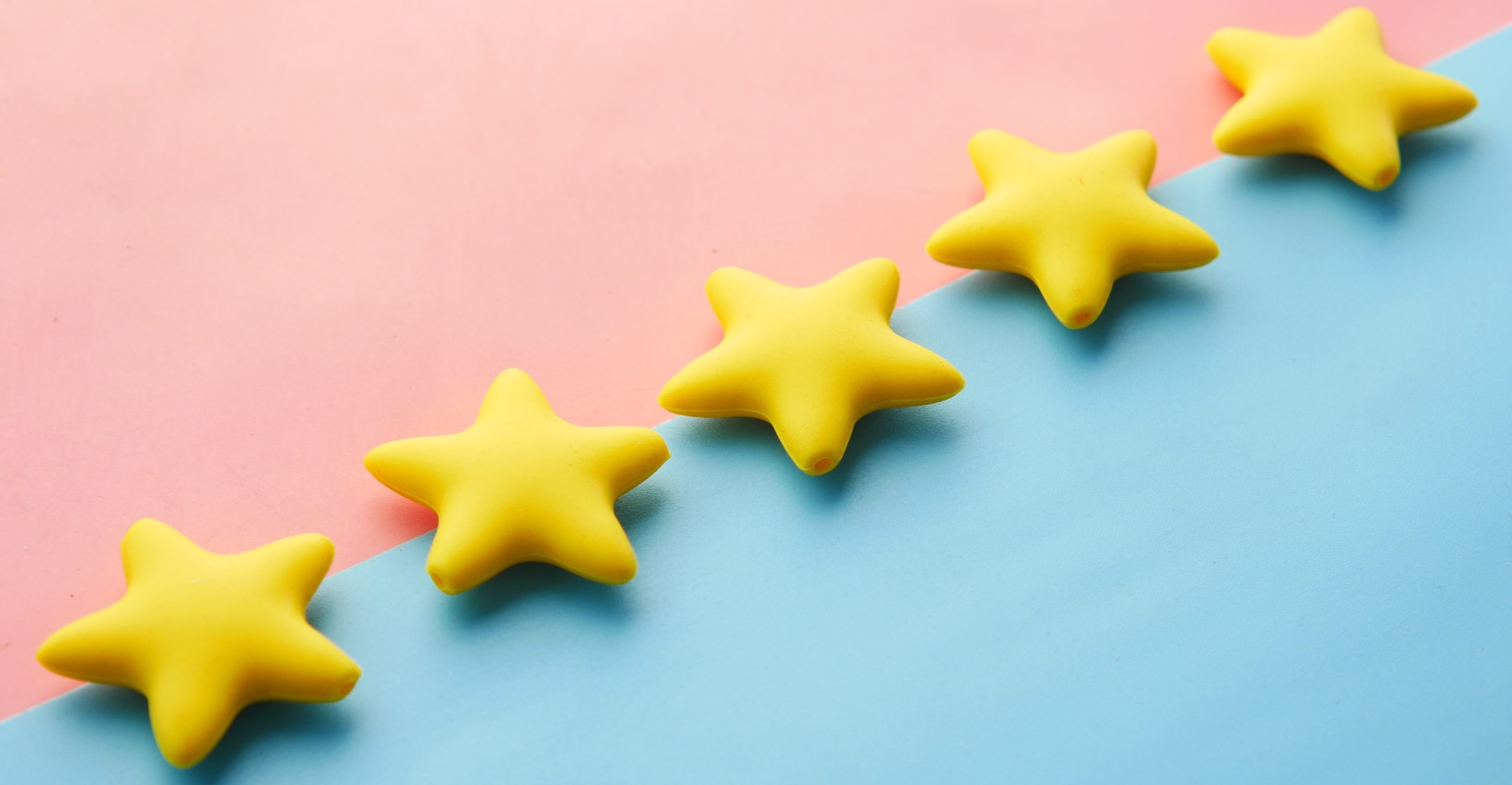 Five yellow stars lined up against a pink and blue background.