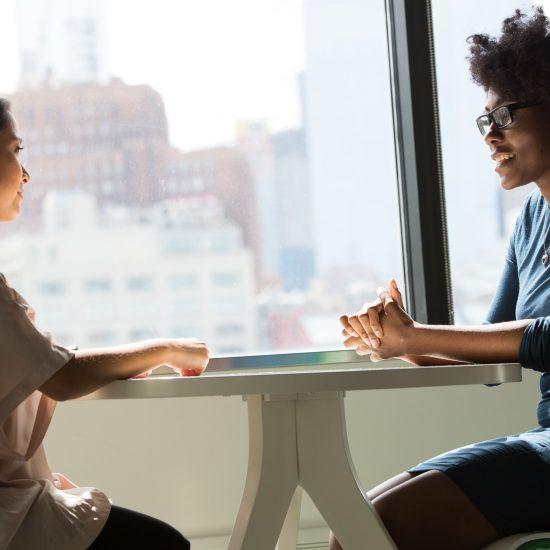 Two women in a meeting as part of an article about client referrals.