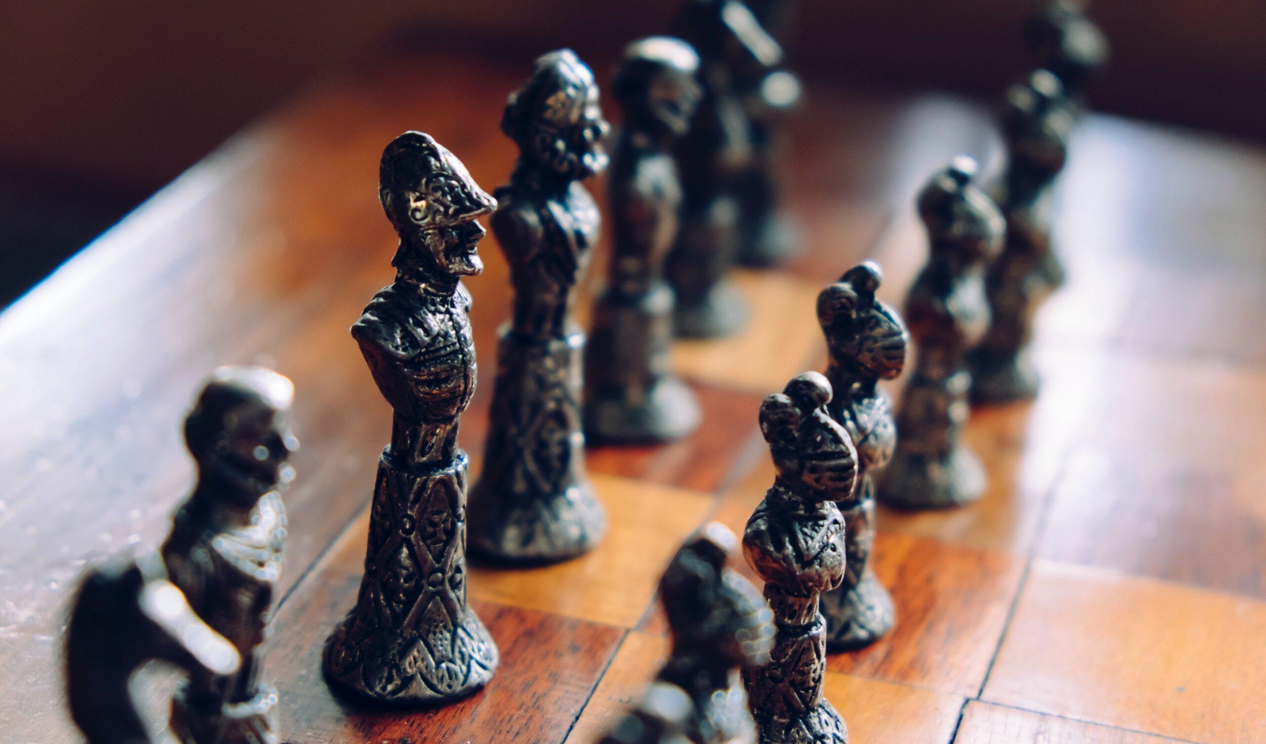 Ancient chess pieces on a chess board as part of an article about creating the ultimate sales playbook.