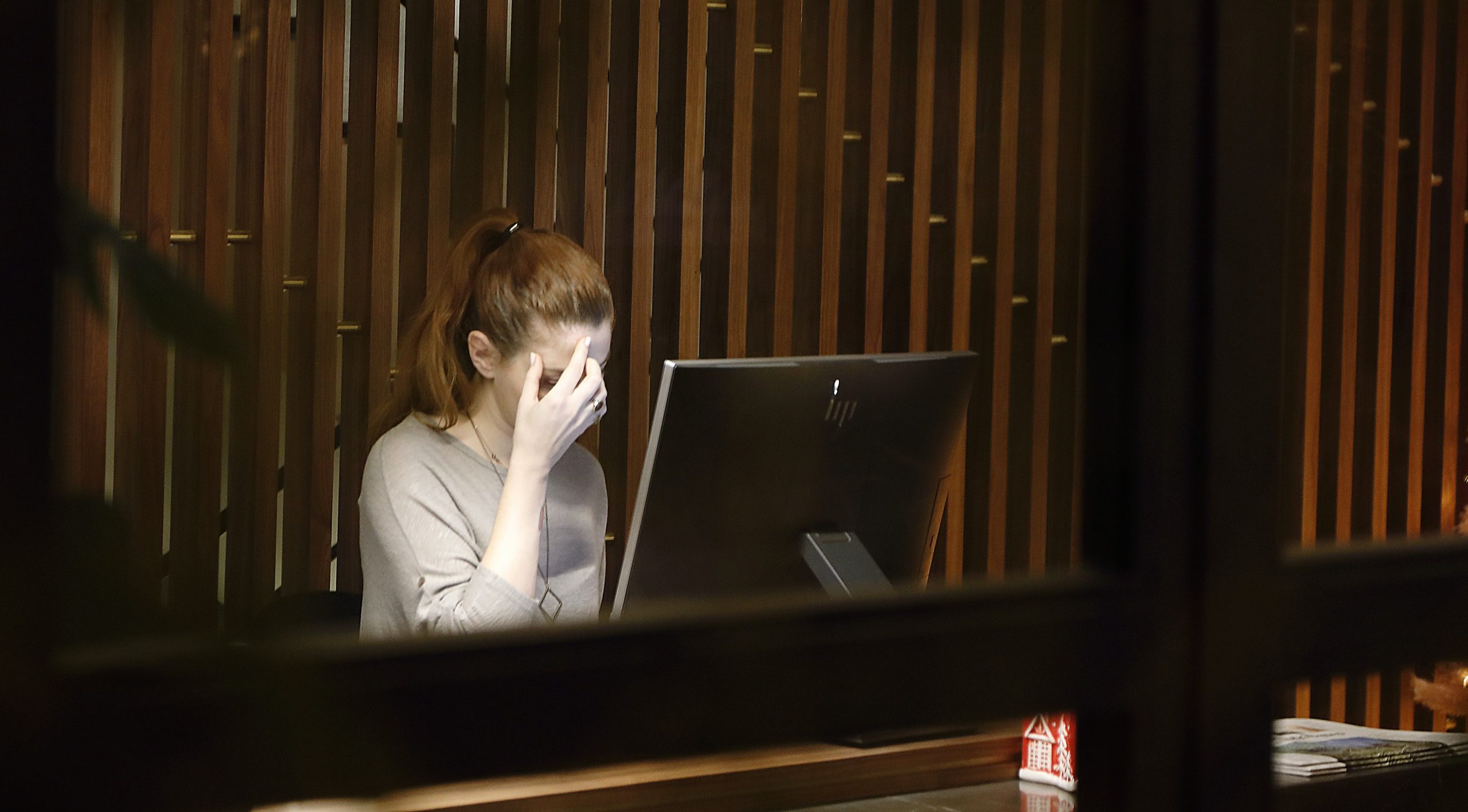 Woman in front of a computer looking stressed - as we reveal why accountants need a CRM in their lives.