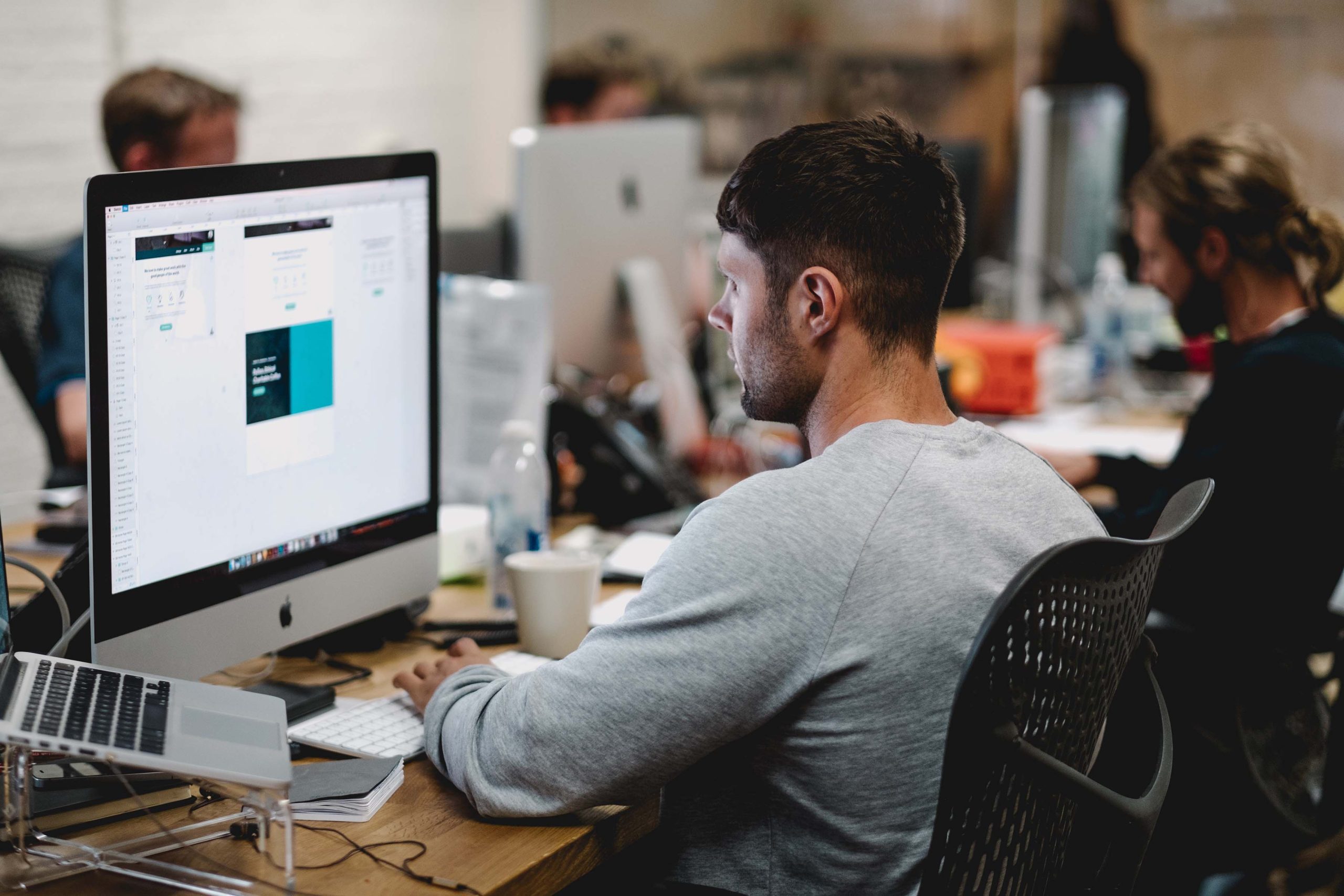 Man sitting in office looking at computer screen.