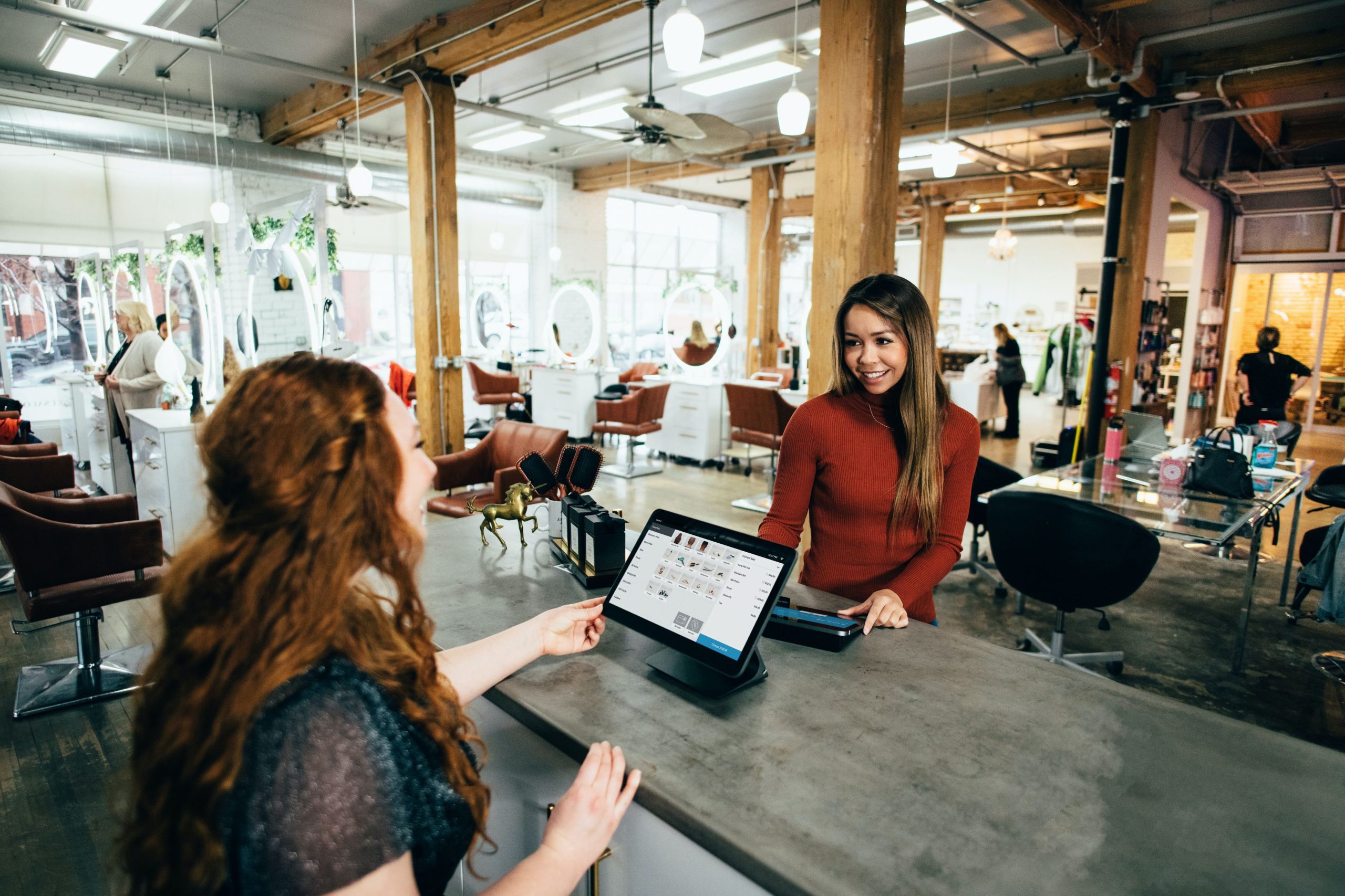 An employee and a customer interacting during a transaction.