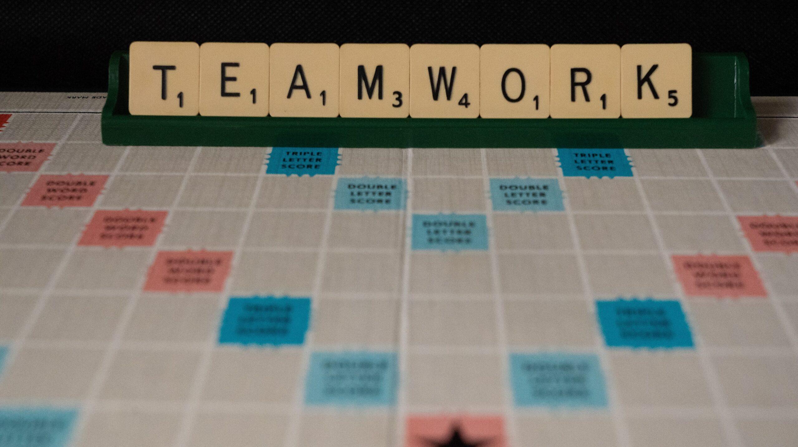 Scrabble letters arranged to form the word, 'teamwork'.