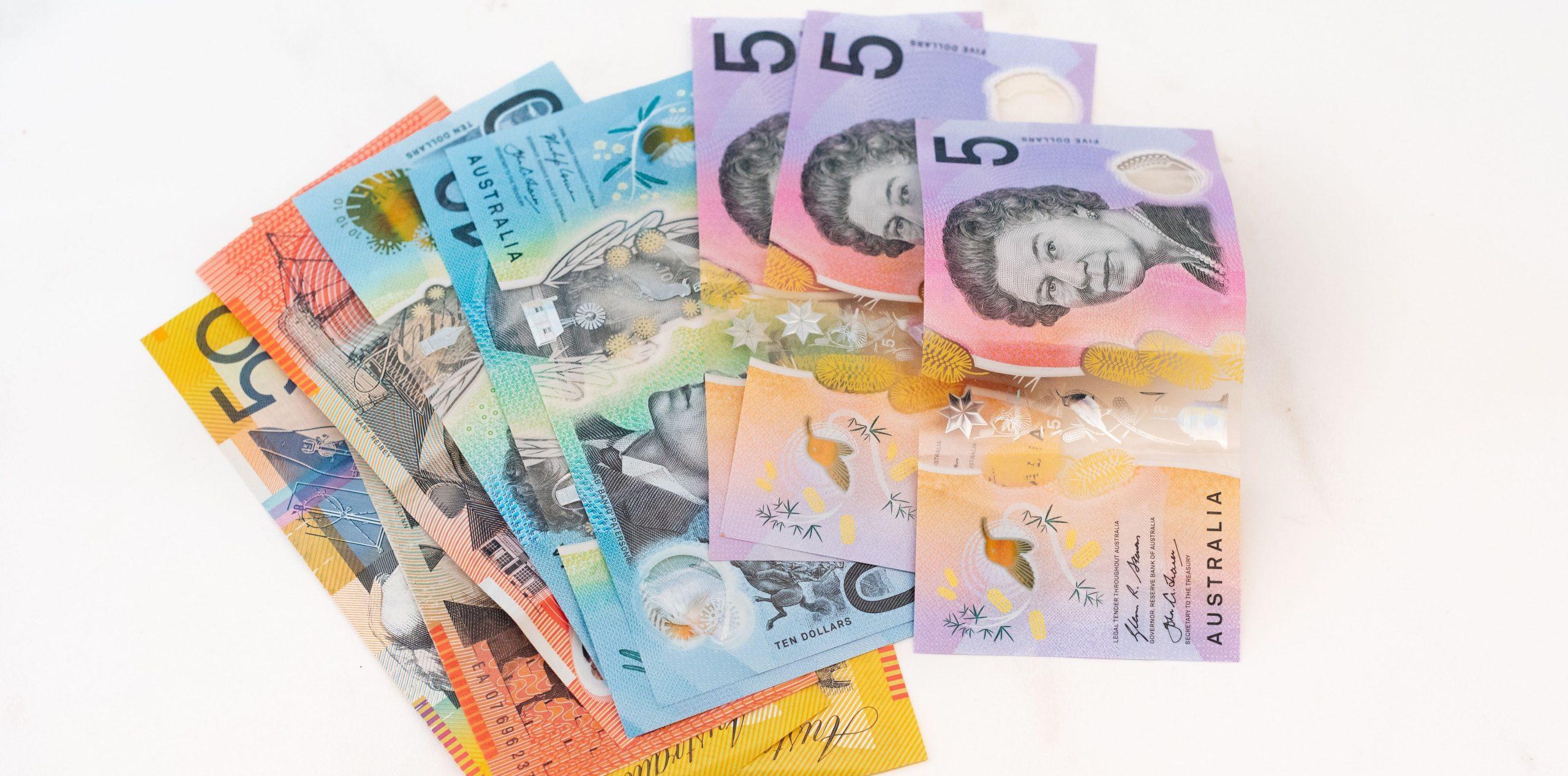 Australian banknotes laid out on a white background.