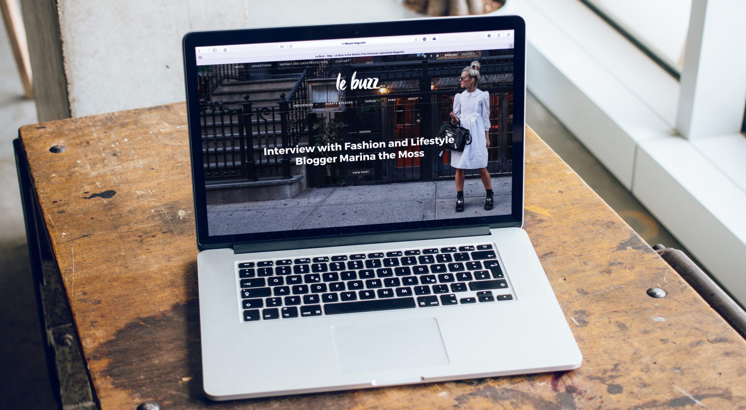 Laptop displaying a fashion website homepage.
