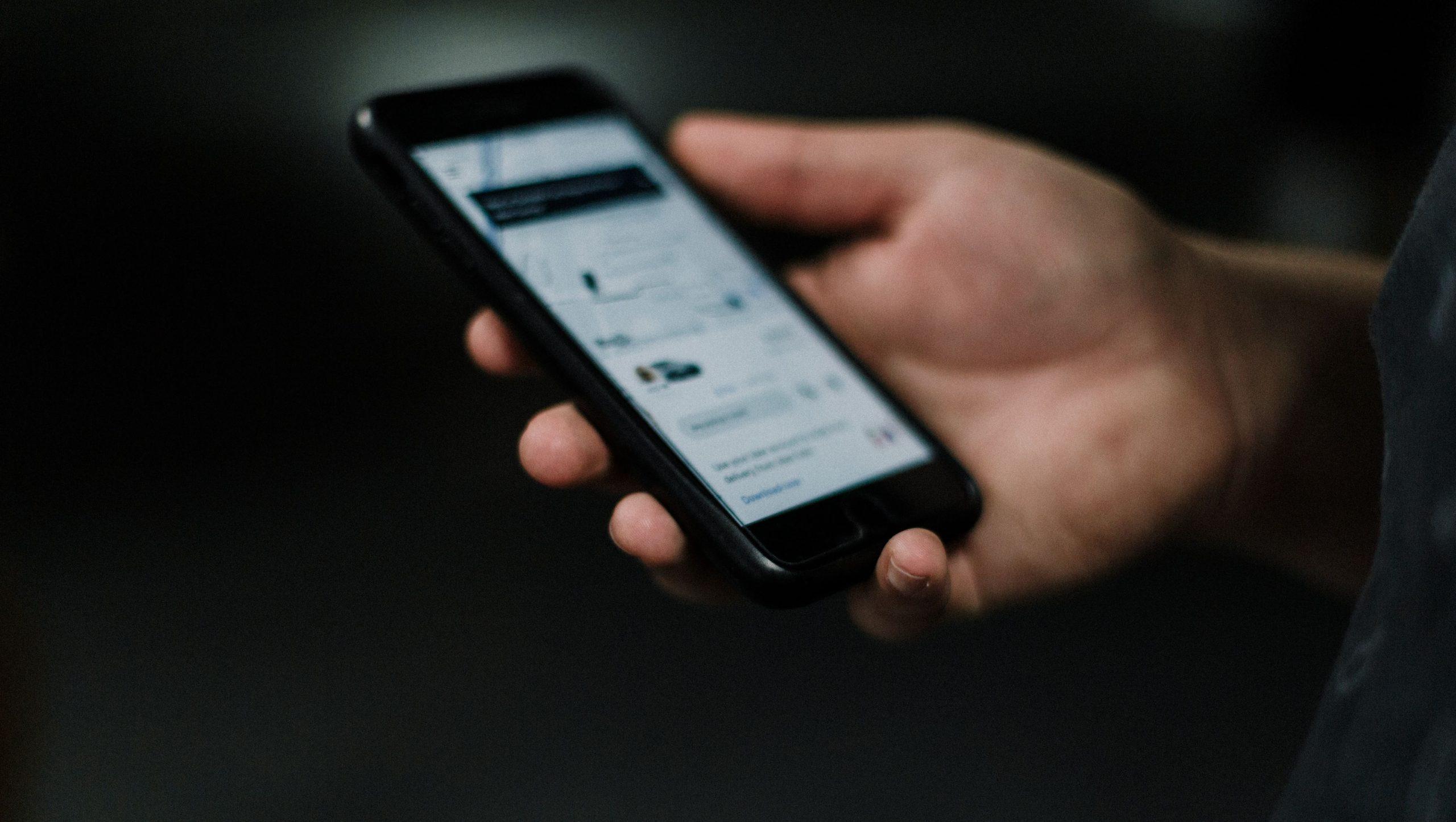 Person holding smartphone displaying the Uber app.