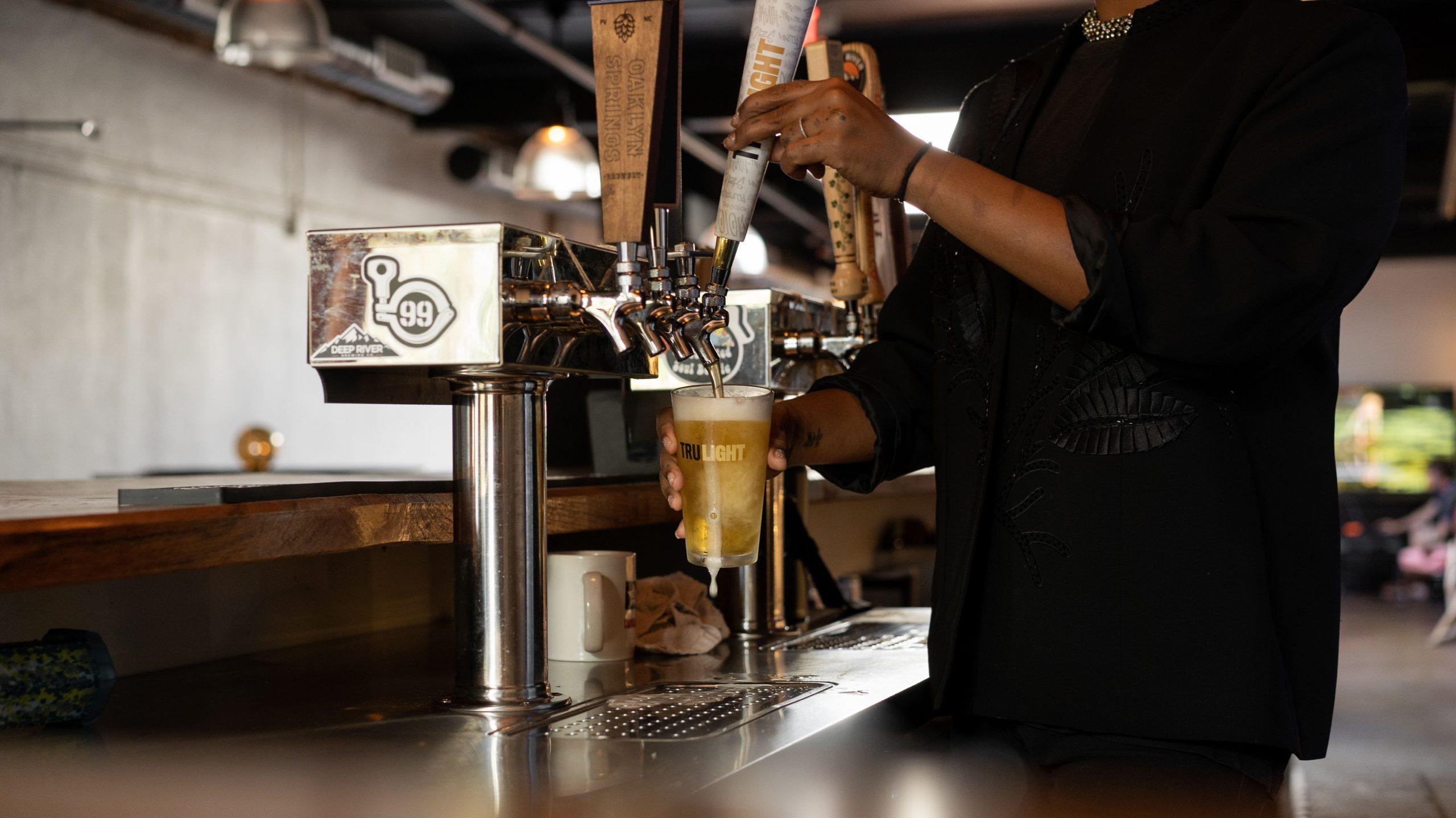 Bartender pouring a beer in a brewery.