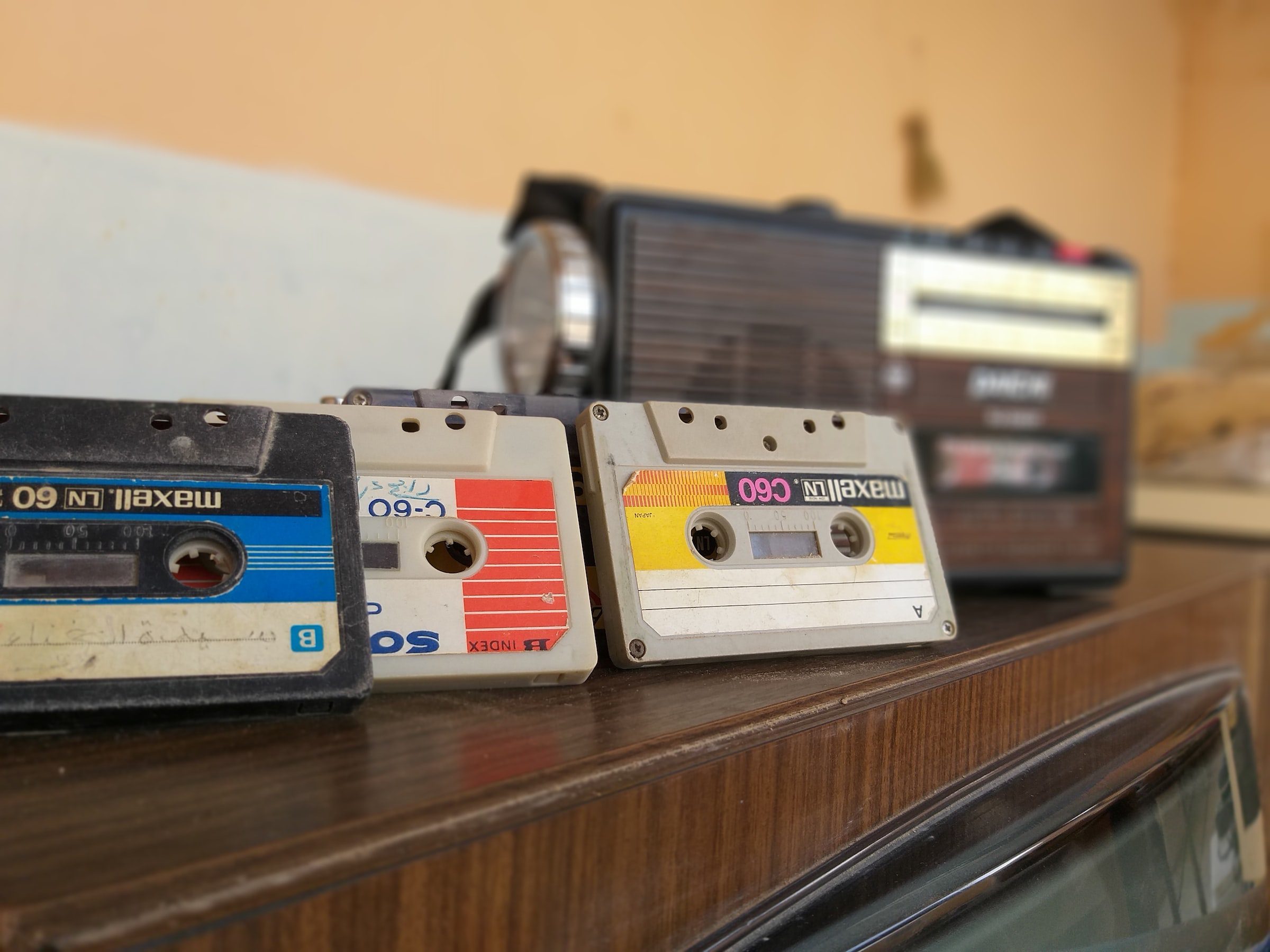 Old cassette tapes and a transistor radio, which are instrumental in the history of portable music players.