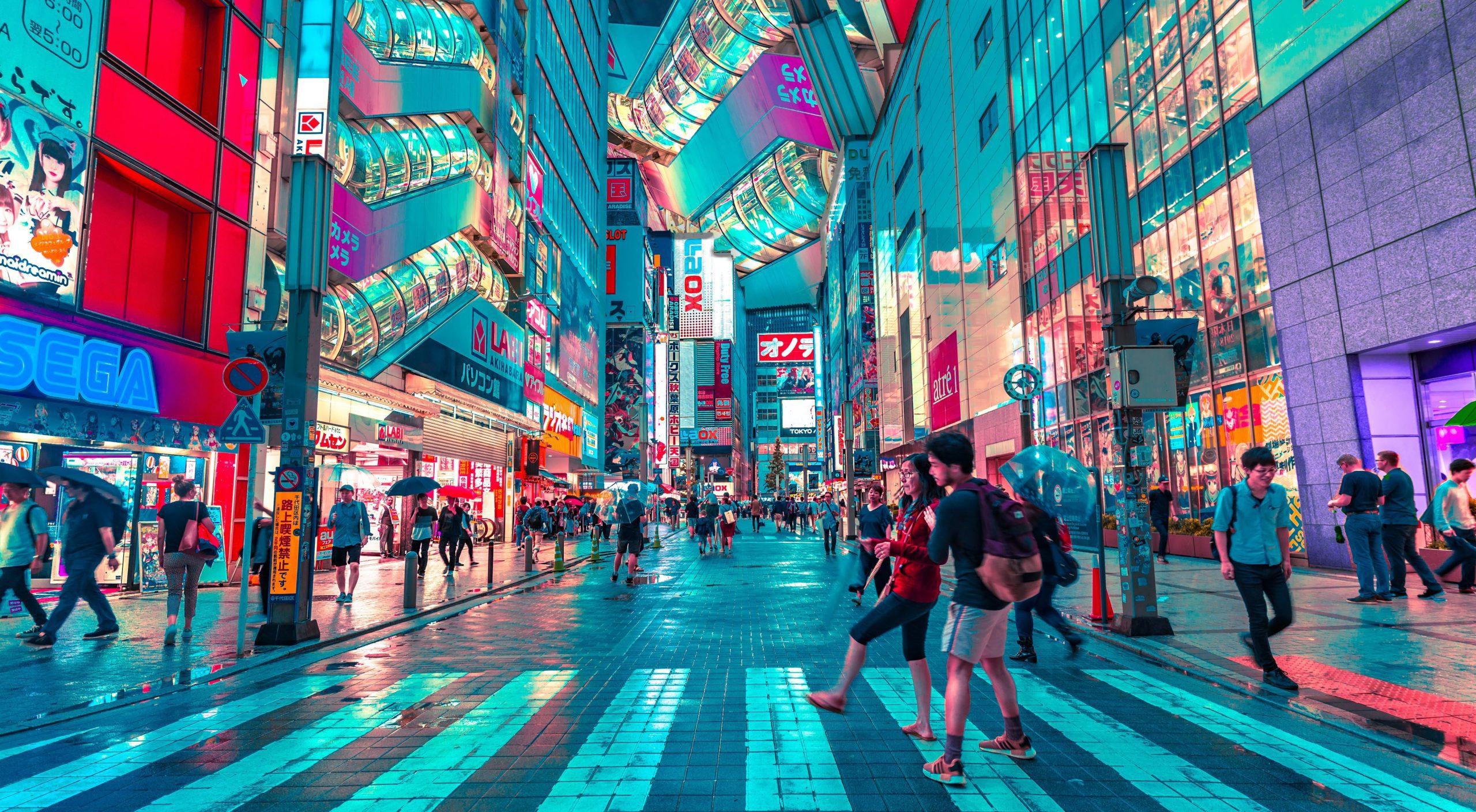 People walking around a neon-lit Japanese city.