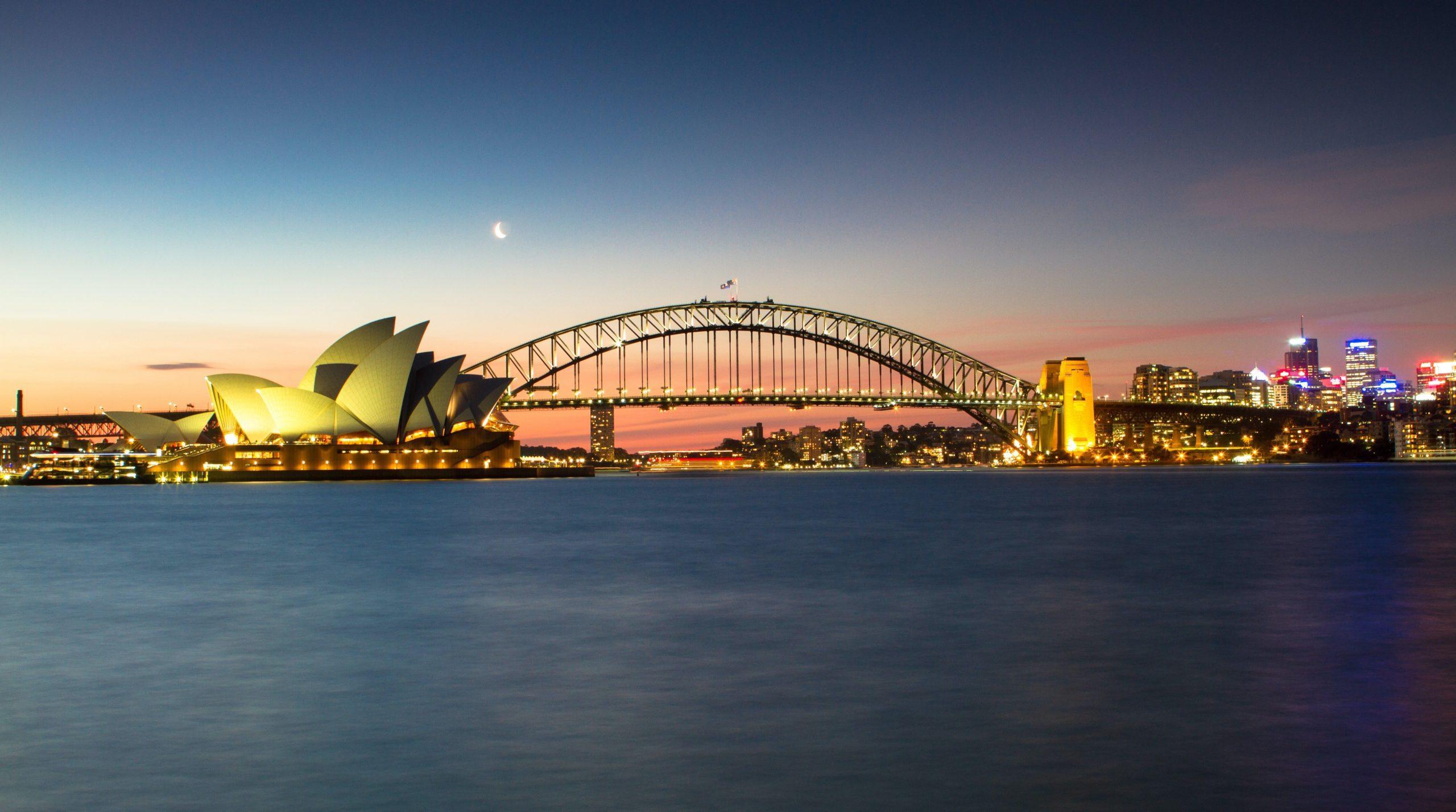 Sydney Opera House and the Sydney Harbour Bridge at sunset.
