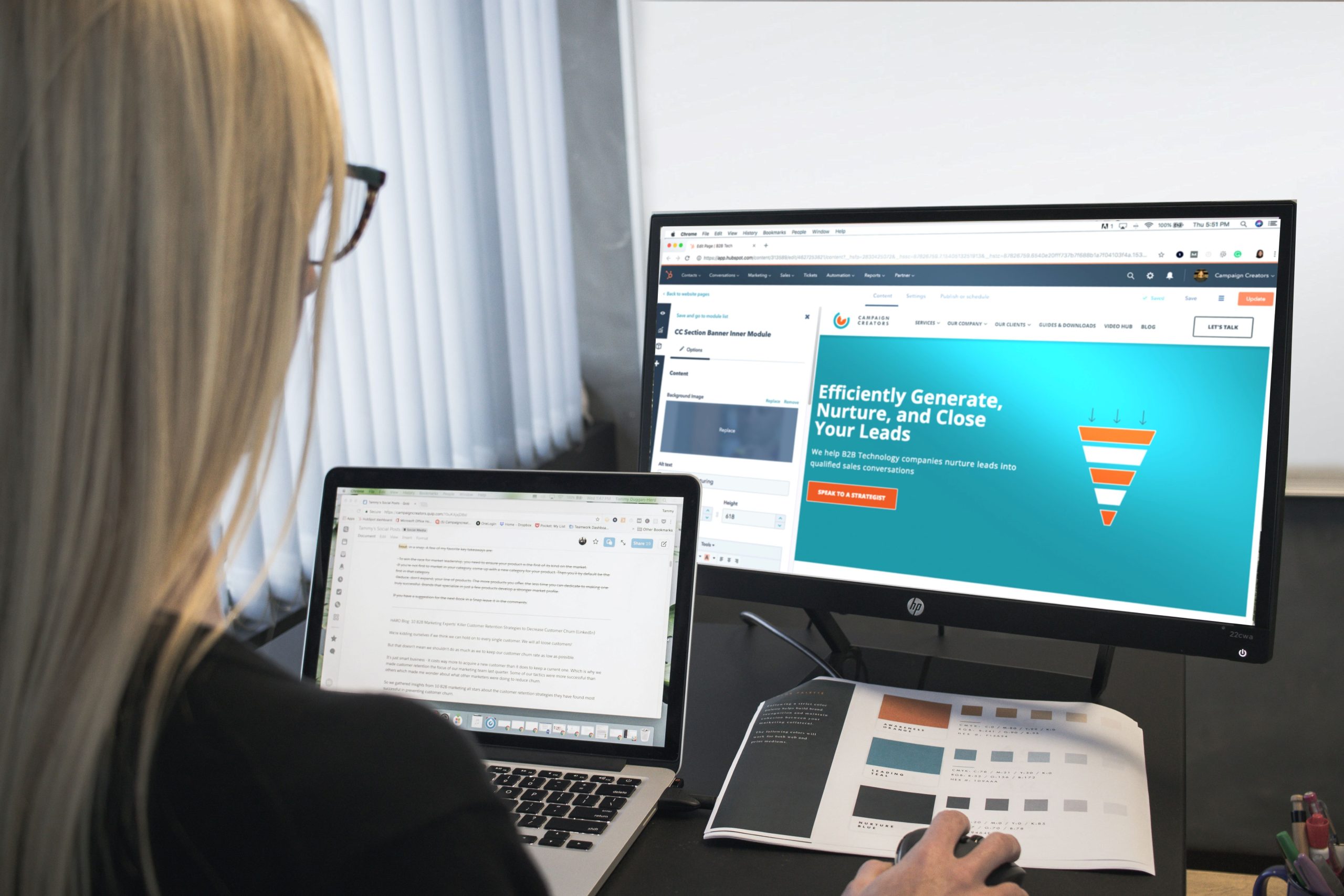 Woman looking at laptop and monitor with HubSpot pages displayed.