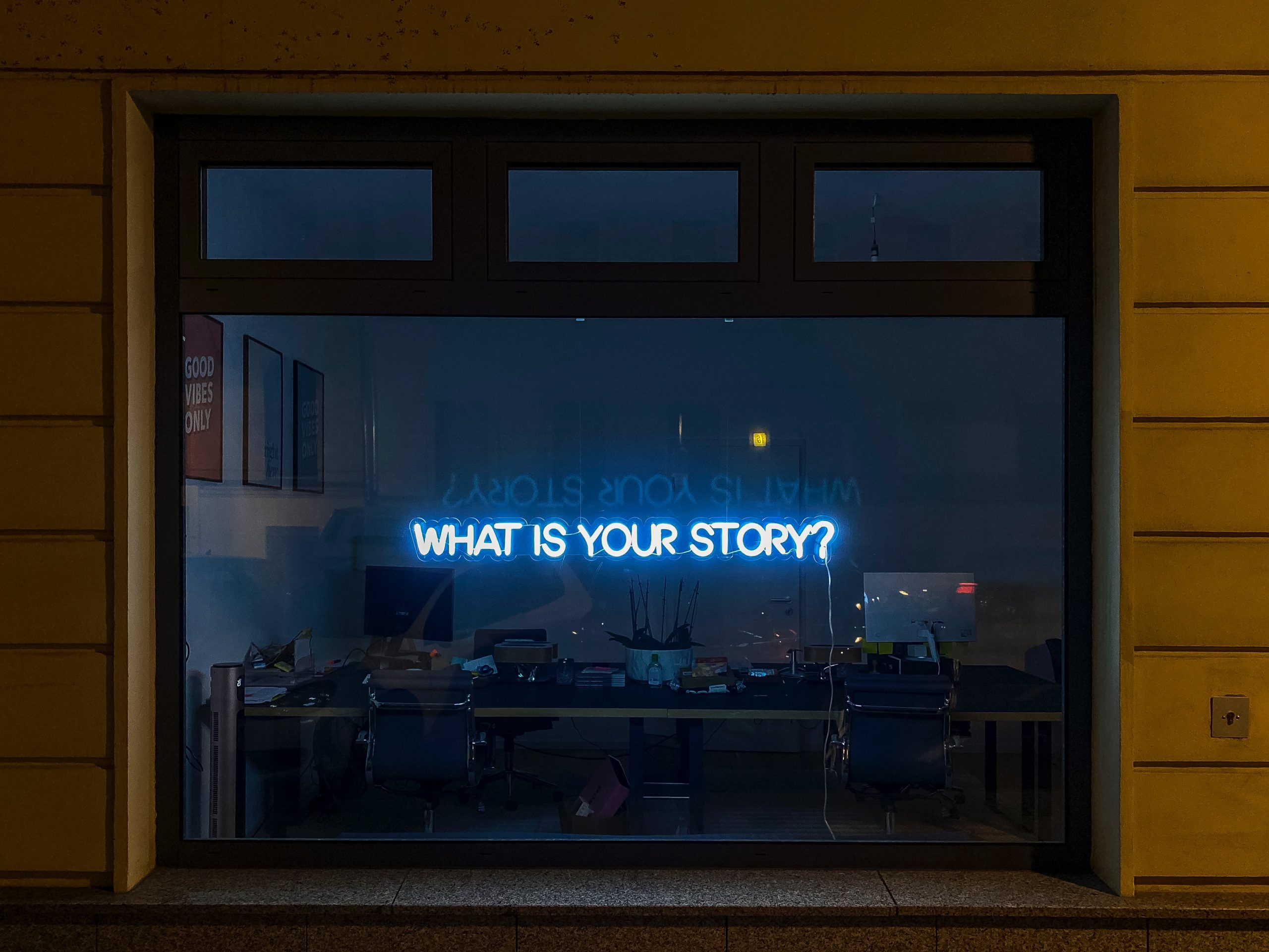 Neon sign with the words 'What is your story?'