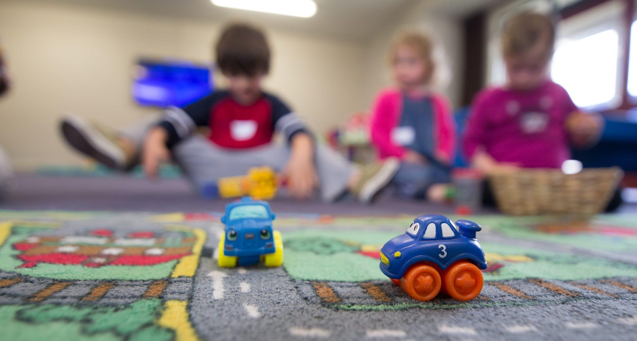 Playmat with car in front of children at a daycare centre.