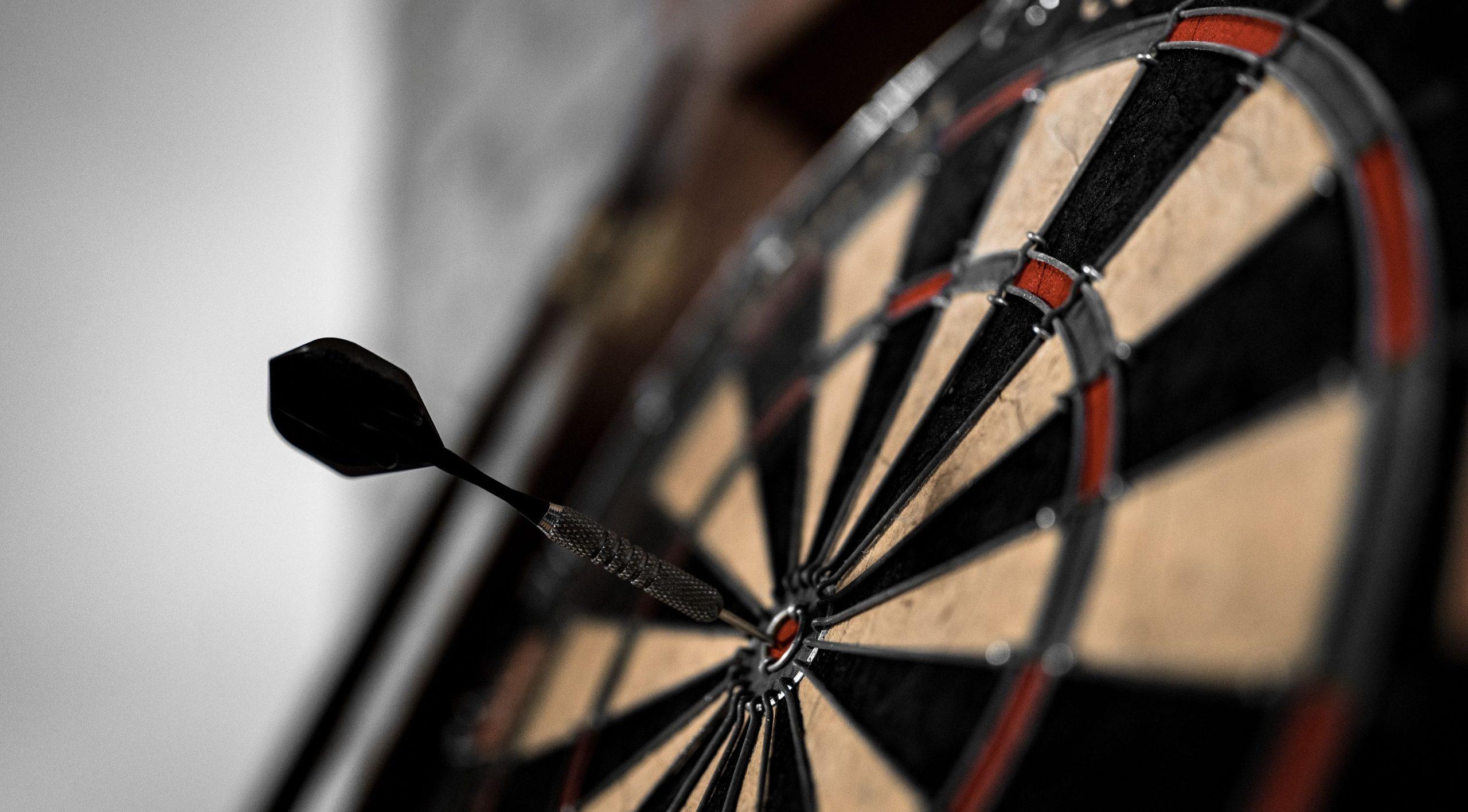 Close up of a dartboard with a dart placed in the bullseye.