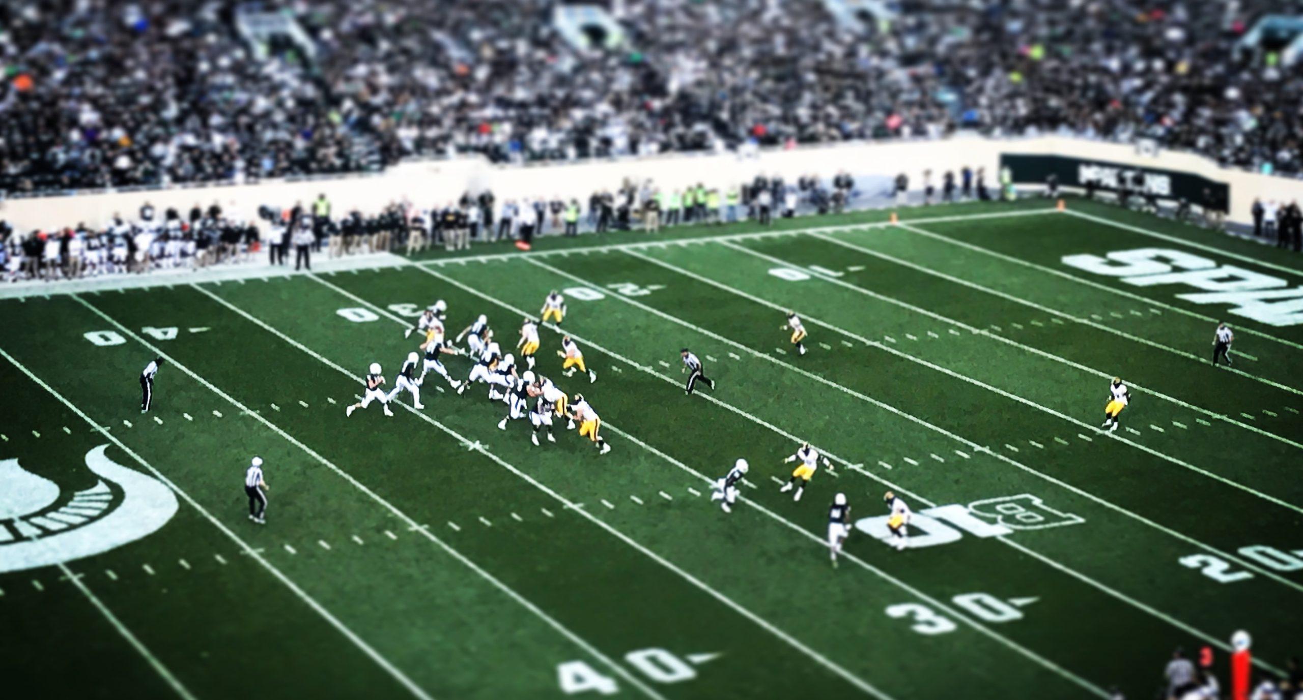 American football match played in a packed stadium.