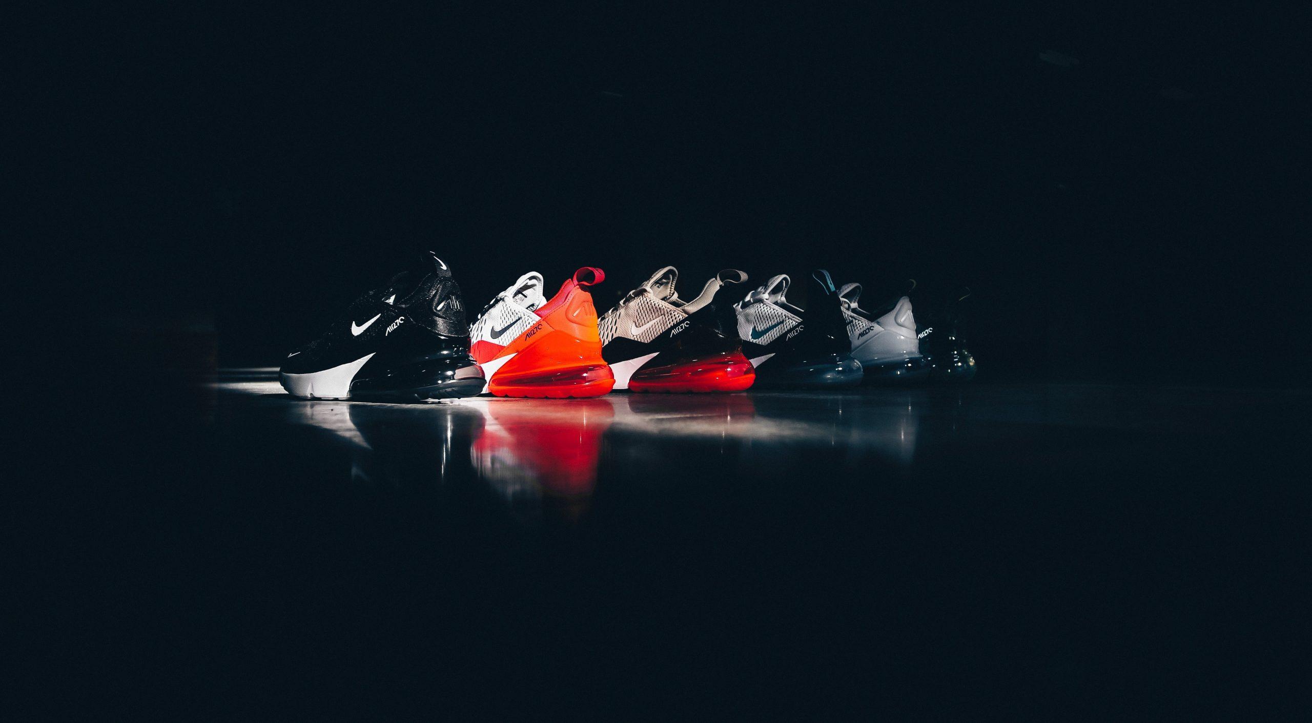 Pairs of Nike shoes against a black backdrop.