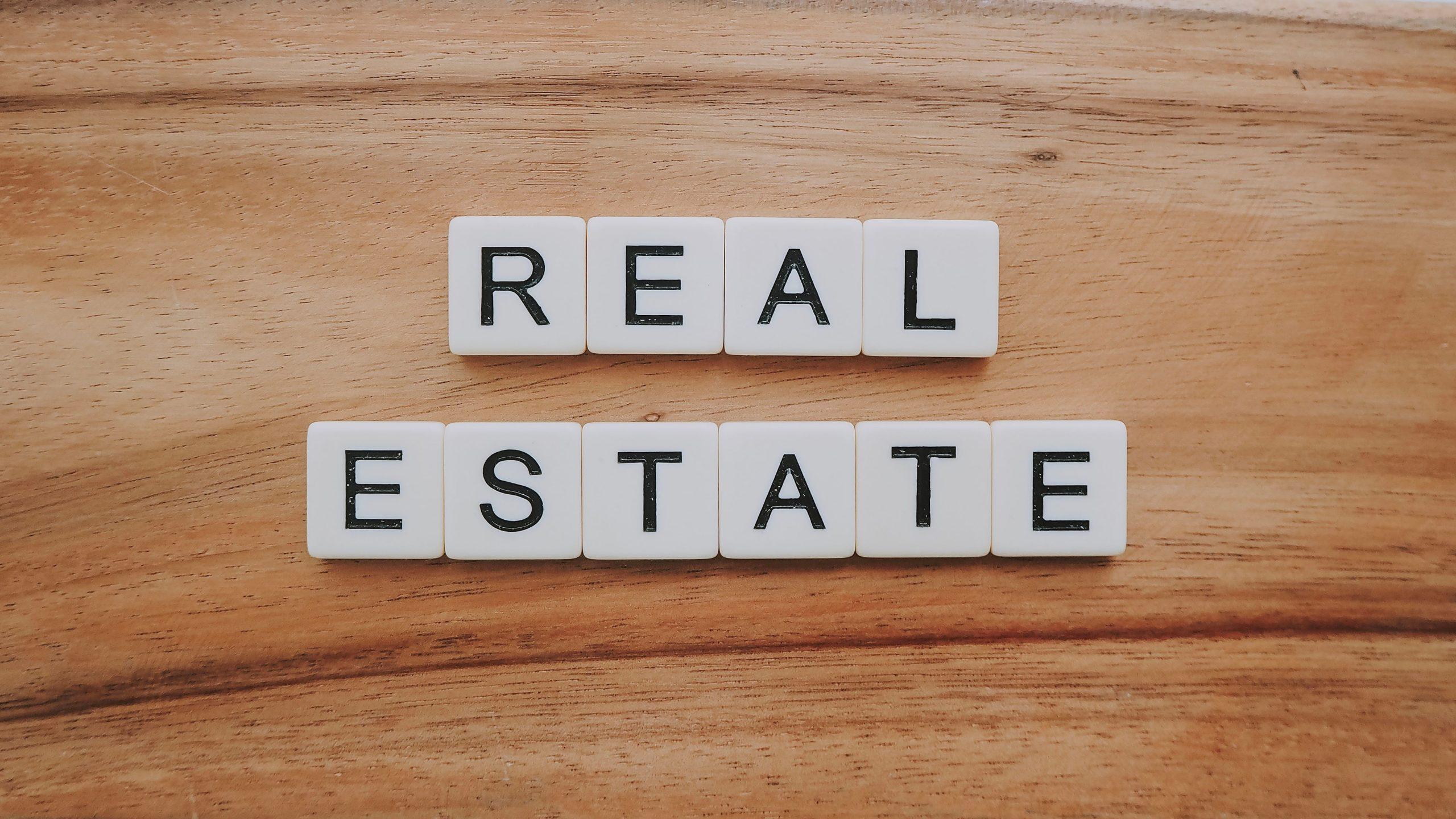 Scrabble-style letters arranged to spell the words 'real estate'.