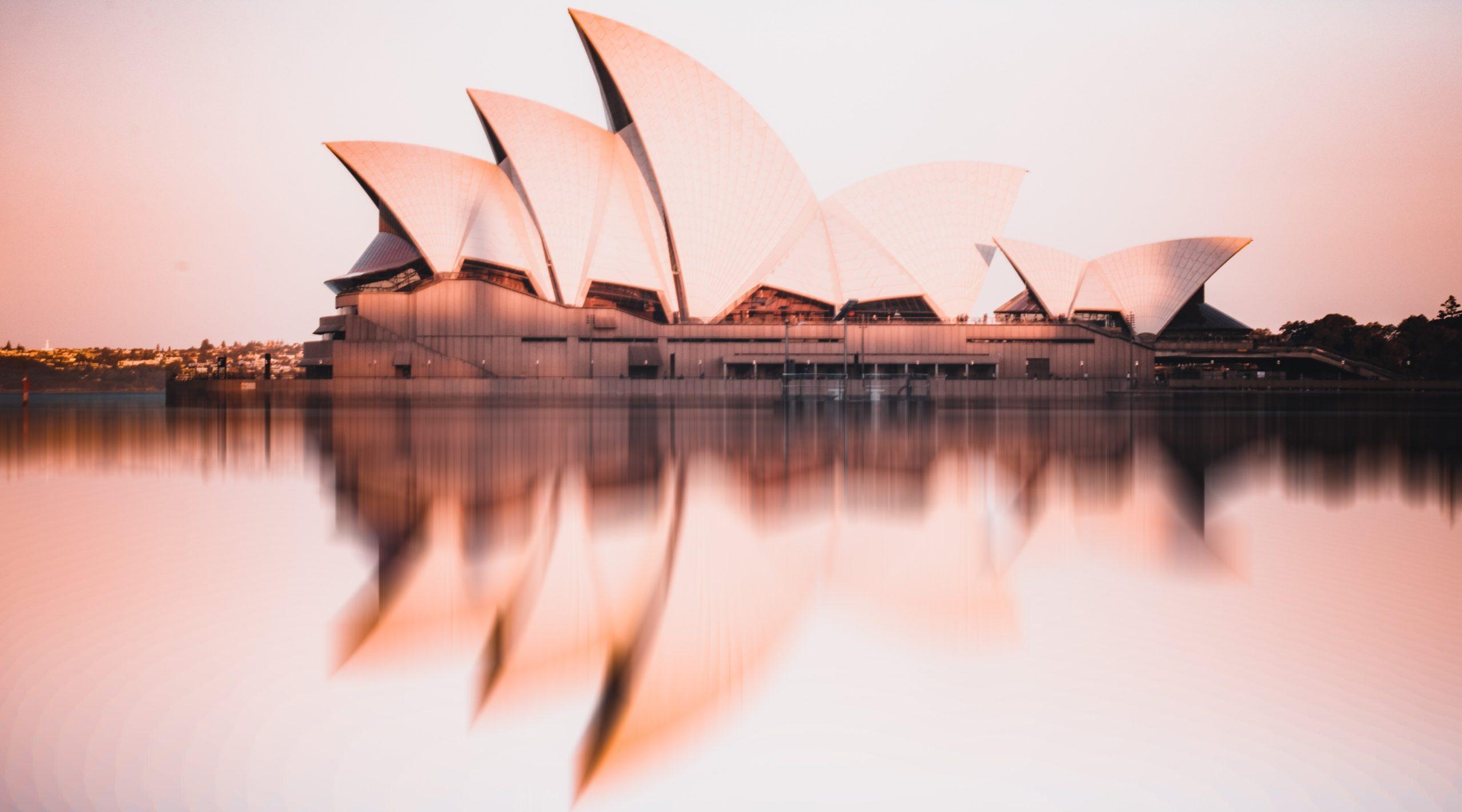 Sydney Opera House, including a reflection of the building on the water.