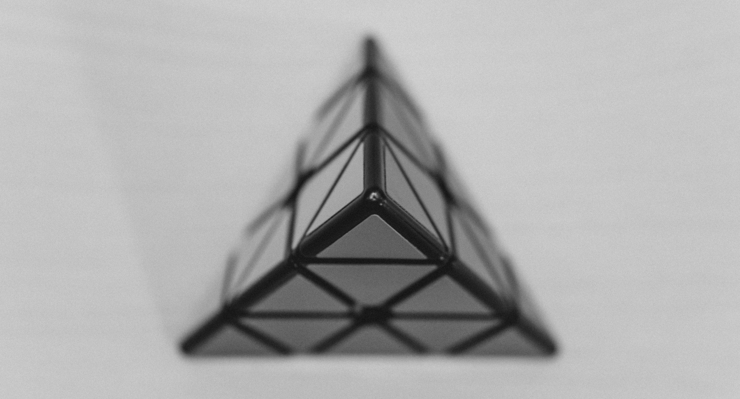 Black and white coloured triangle against a white background.