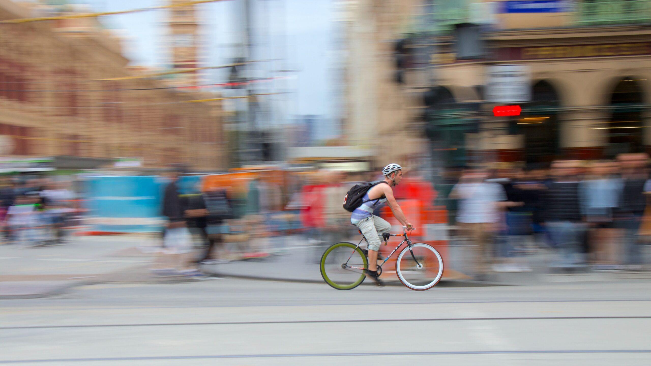 Male cyclist riding through the CBD in Melbourne, Australia.