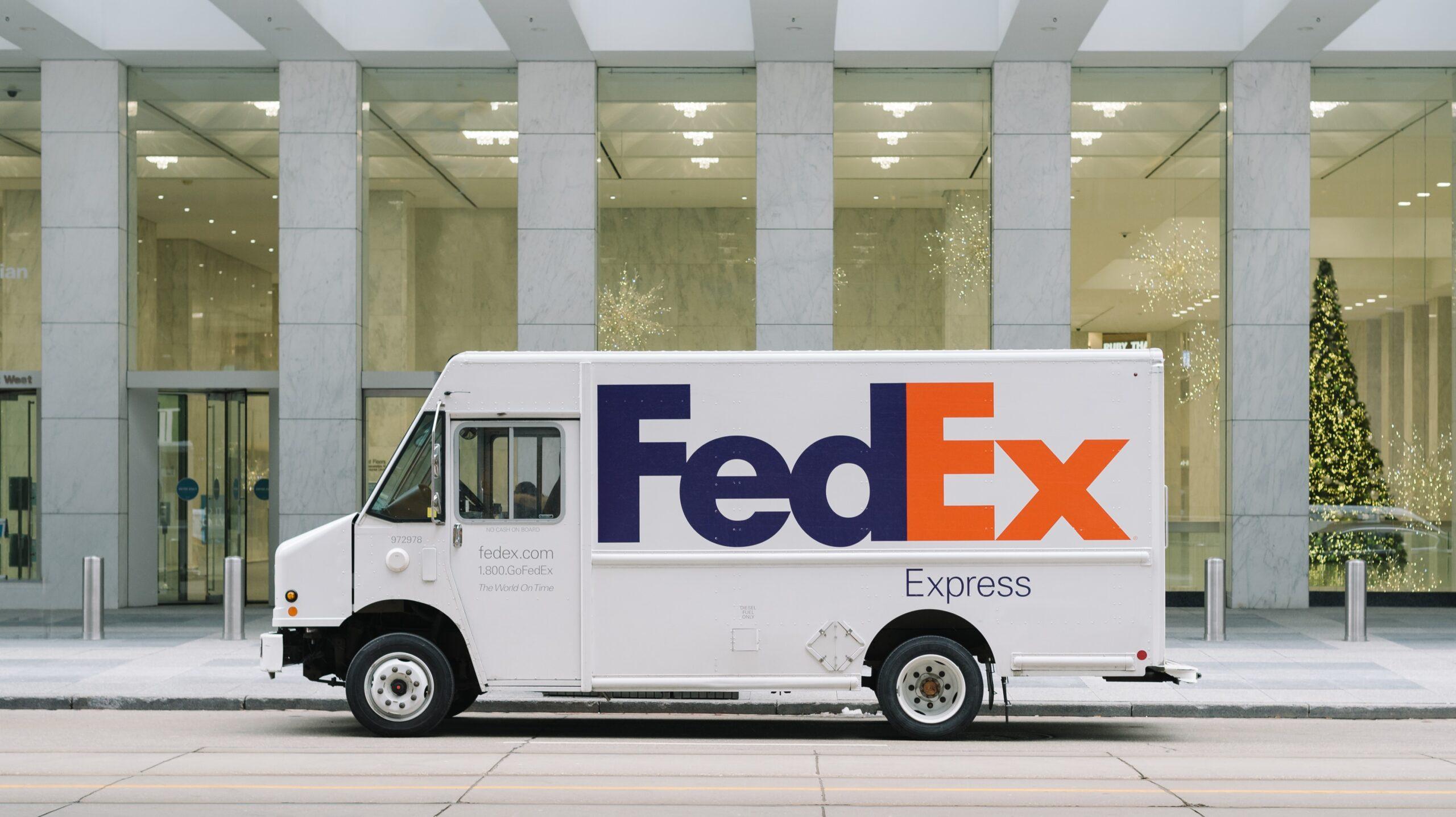 A FedEx van parked outside an office building.
