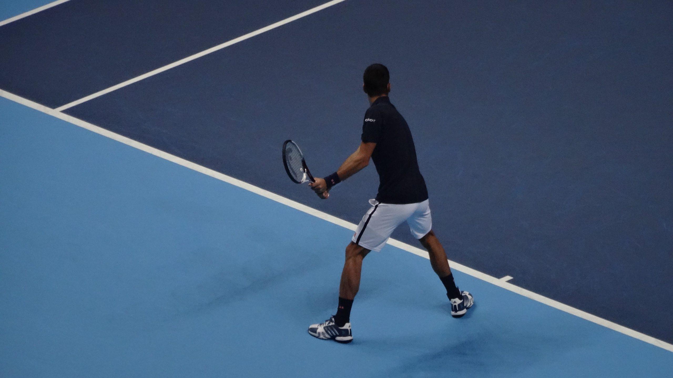 Novak Djokovic looking to return a ball on a tennis court.