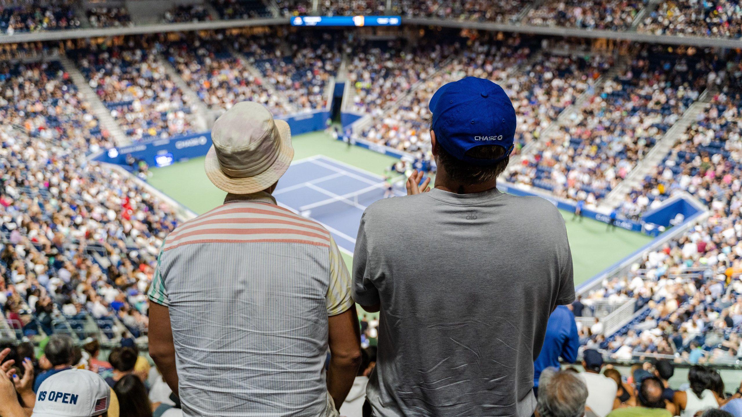 Close up of two spectators watching a match during the US Open tennis tournament.