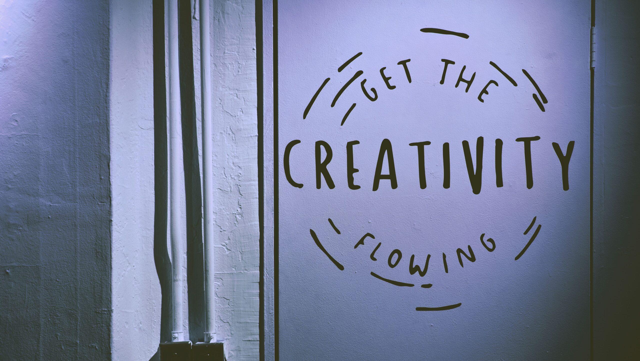 Writing painted on a wall that reads, 'Get the creativity flowing'.