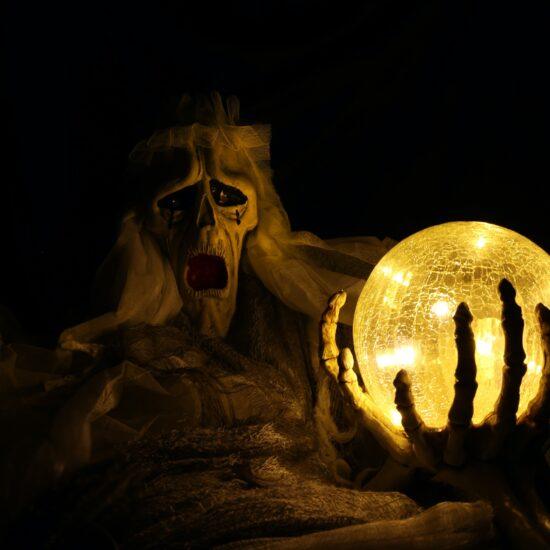 A lantern lit up in front of a ghoulish-looking creature as part of an article about Halloween tech.
