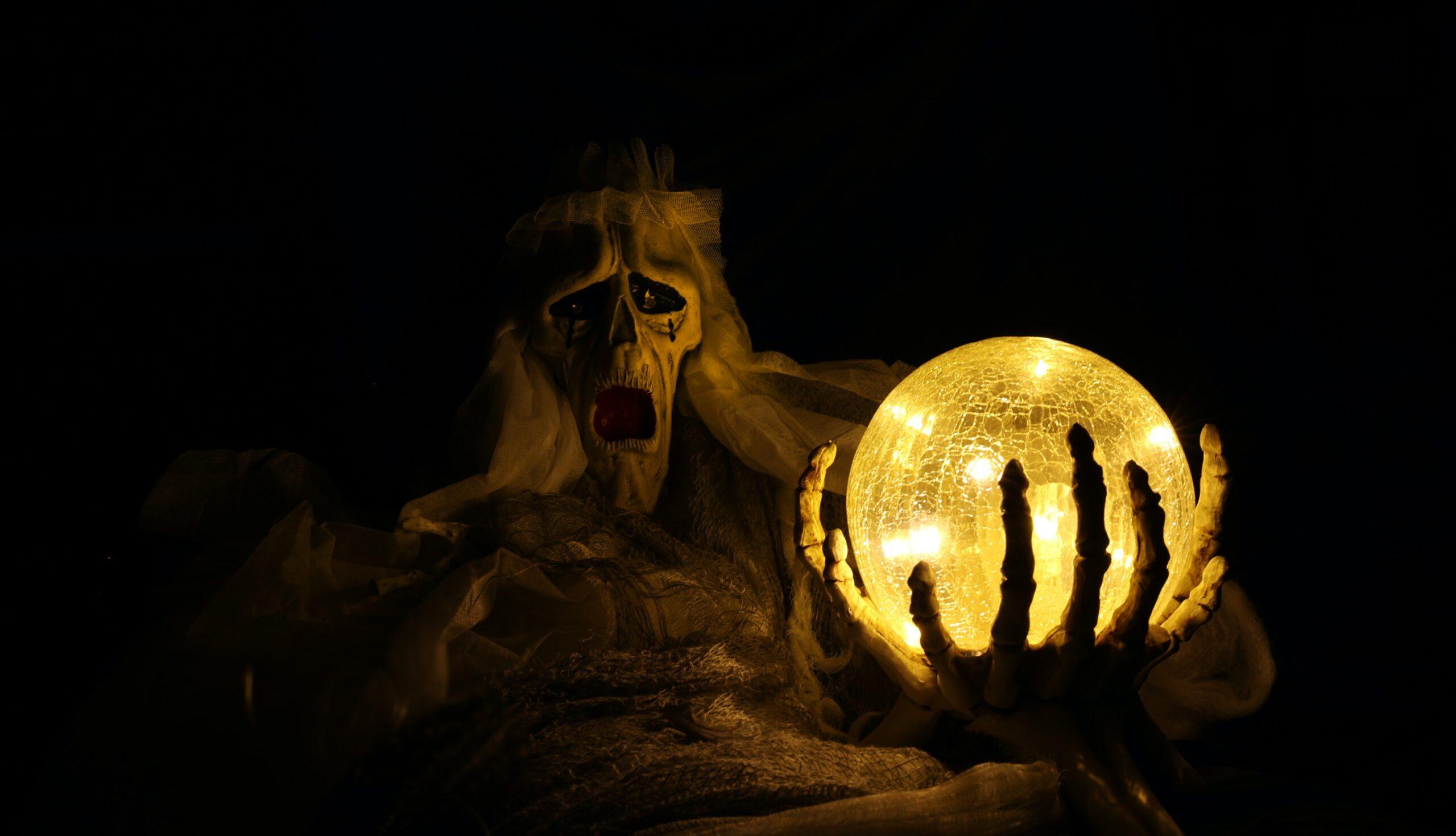A lantern lit up in front of a ghoulish-looking creature as part of an article about Halloween tech.