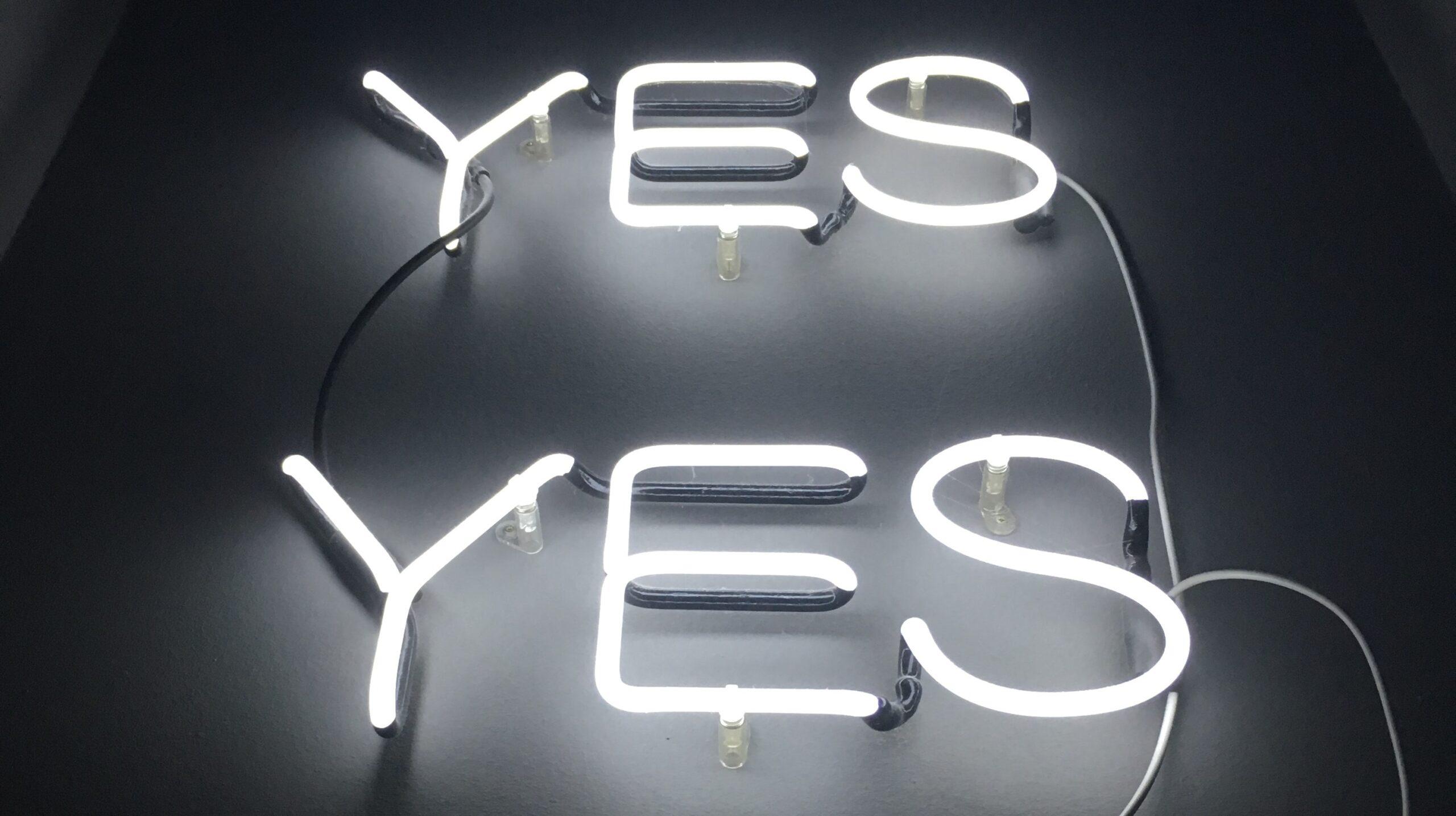 Illuminated sign spelling out the word 'yes' twice.