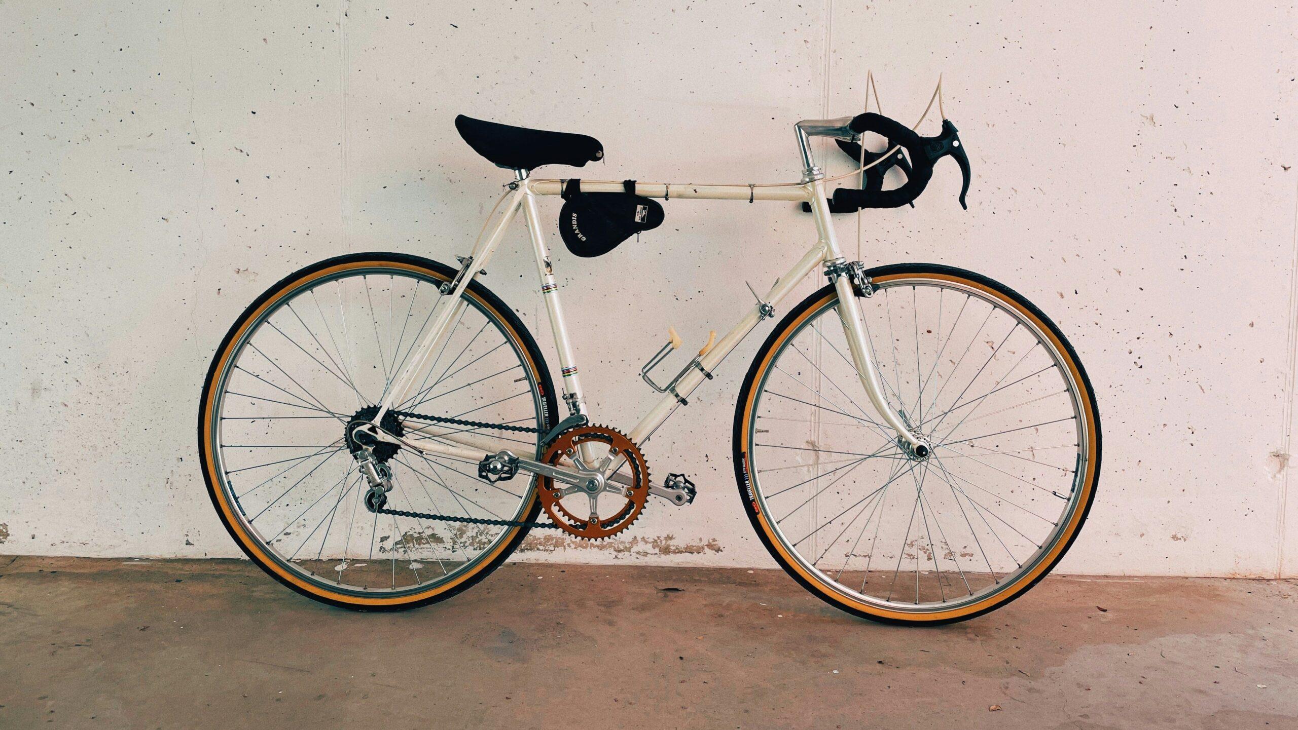 A white Campagnolo bike leaning up against a white wall.