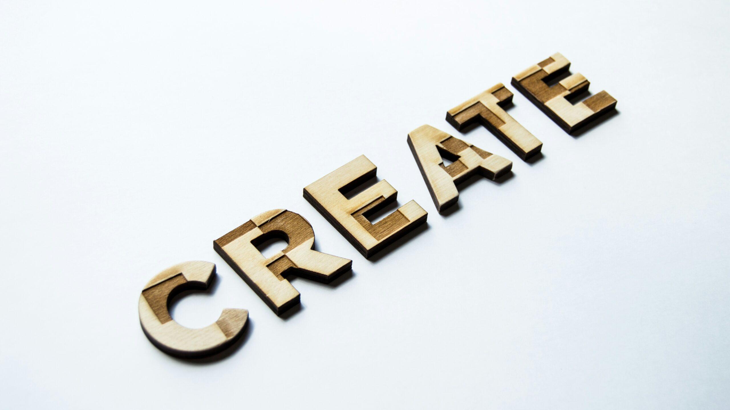 The word 'create' formed in wooden block letters against a white background.