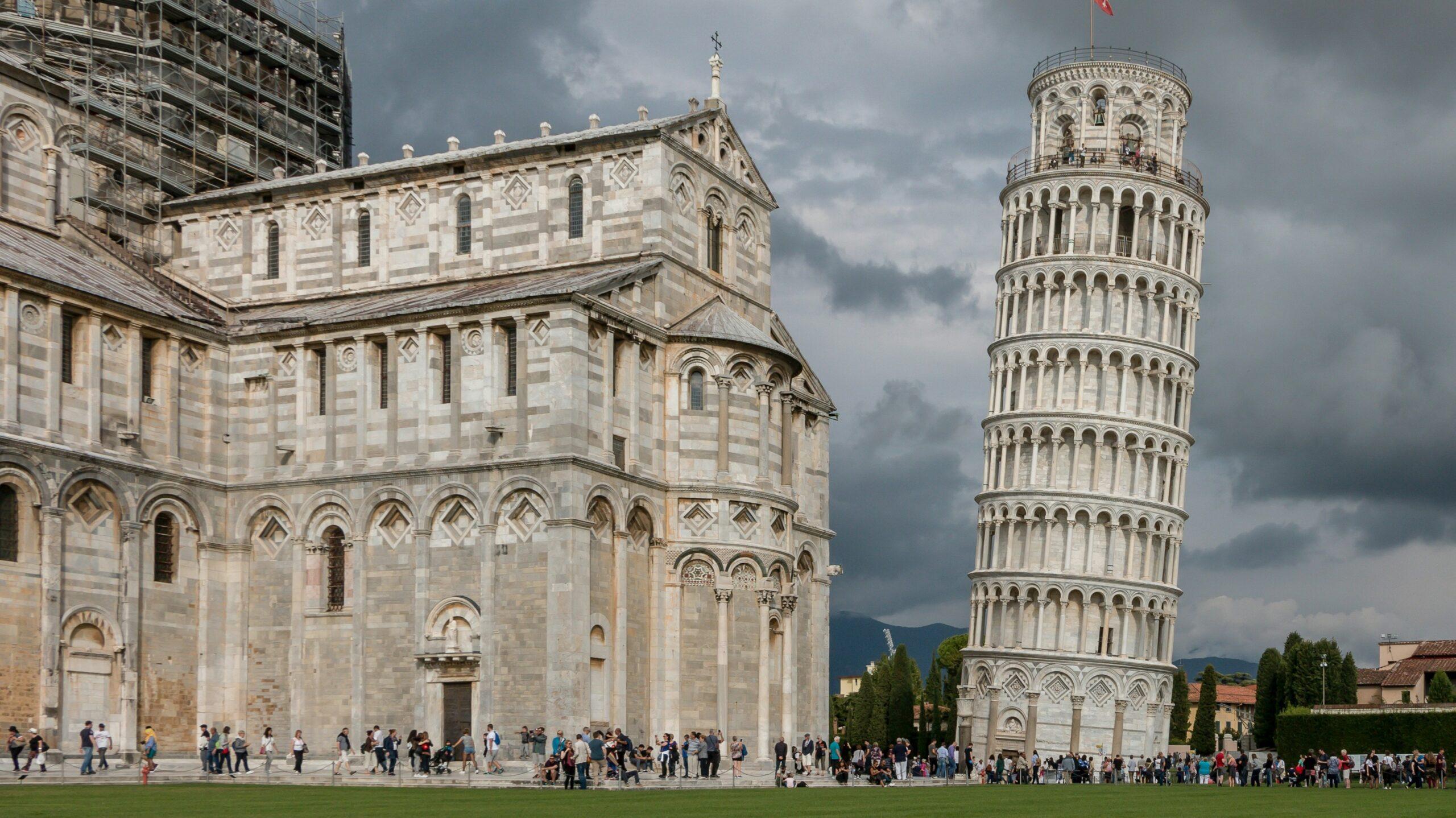 The Leaning Tower of Pisa and the Duomo Pisa (the Pisa cathedral) against a moody backdrop.