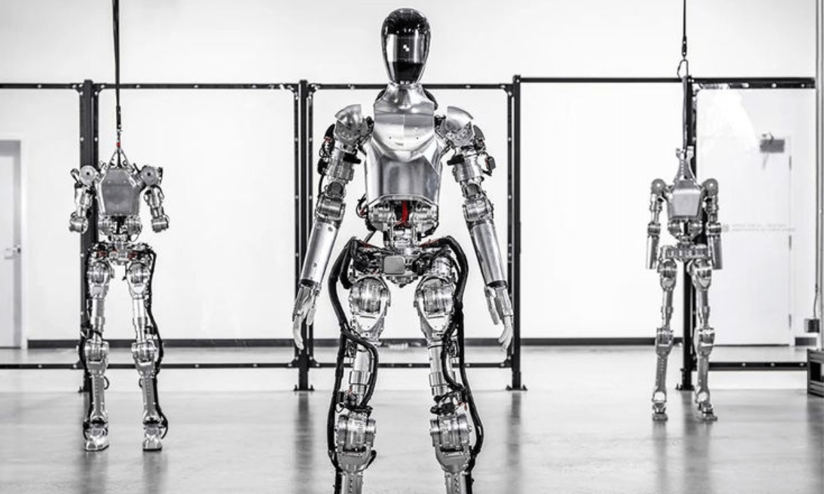 Three humanoid robots standing in front of a glass wall.