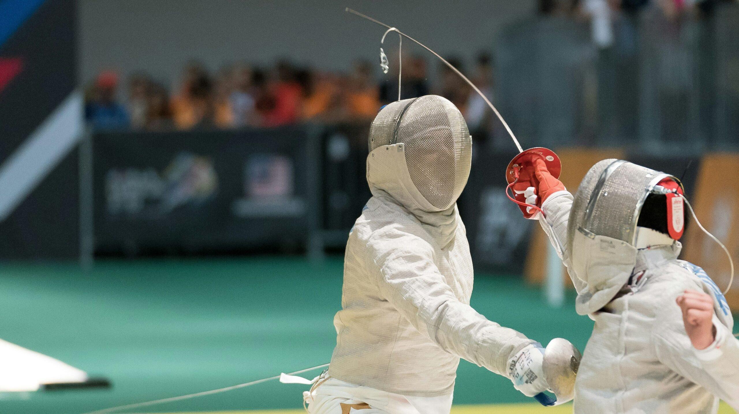 Two competitors battle in a fencing competition.
