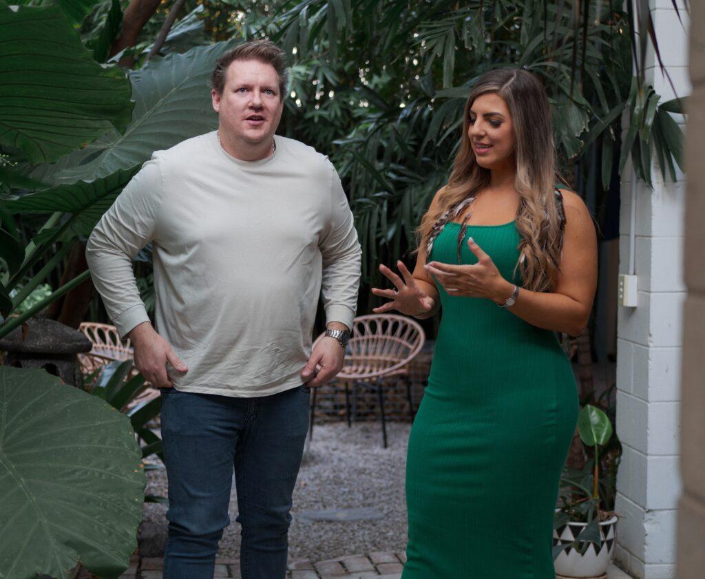 Ryan and Sonya standing side by side in relaxed poses in an outdoor setting.